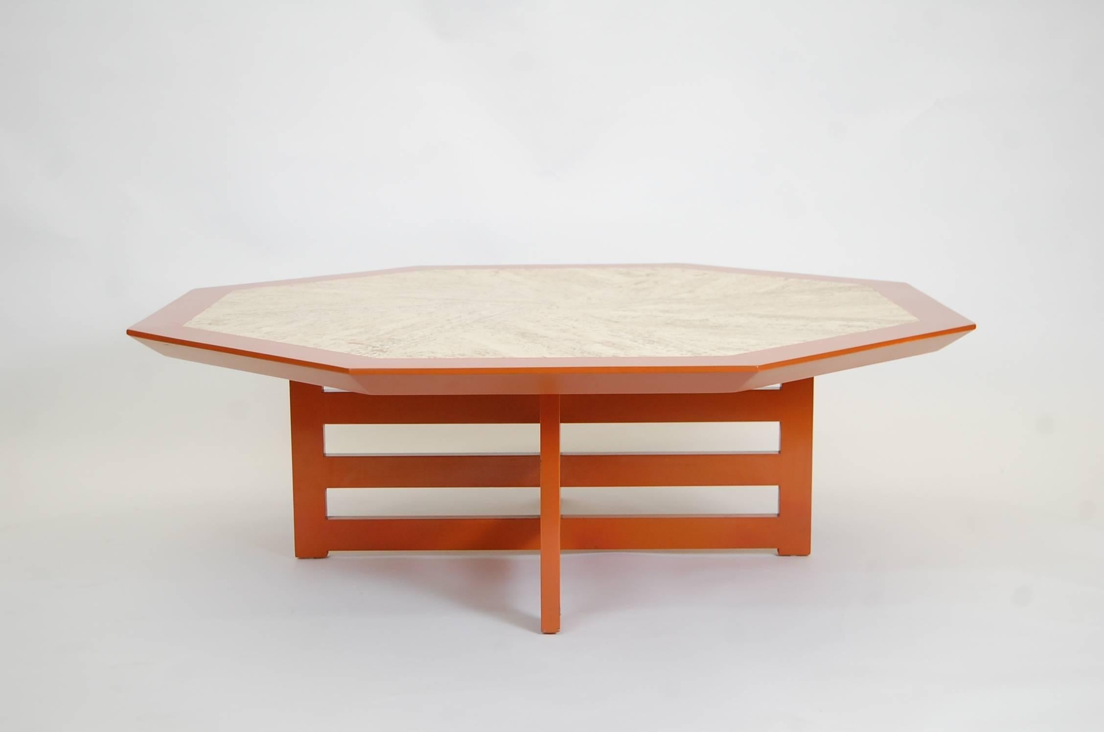 Octagonal travertine top coffee table in orange lacquer, designed and produced by Harvey Probber, circa 1958.
