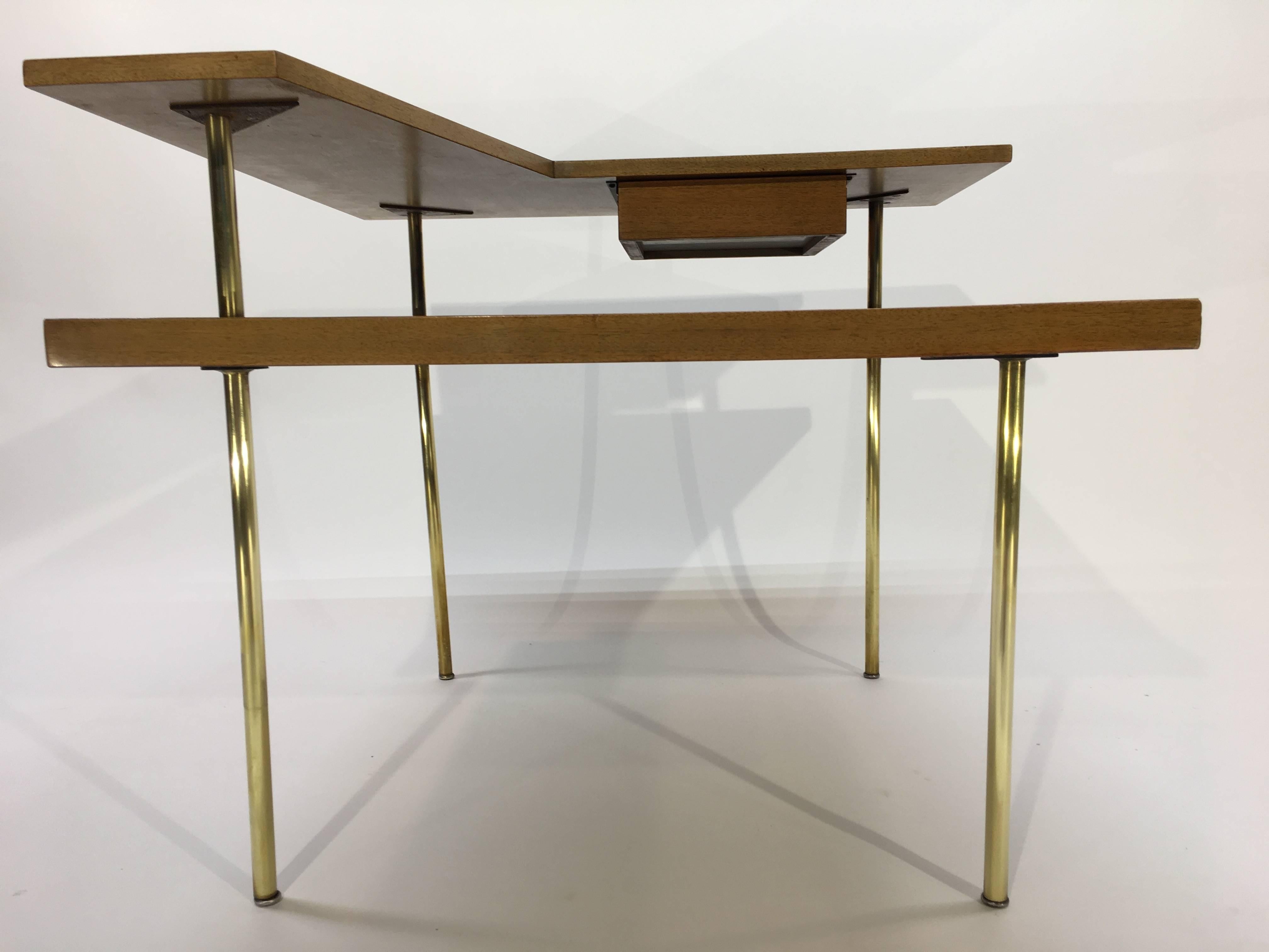 An Atomic era corner table by Harvey Probber having a single drawer and brass legs.
Measure: Height to first table is 19.75