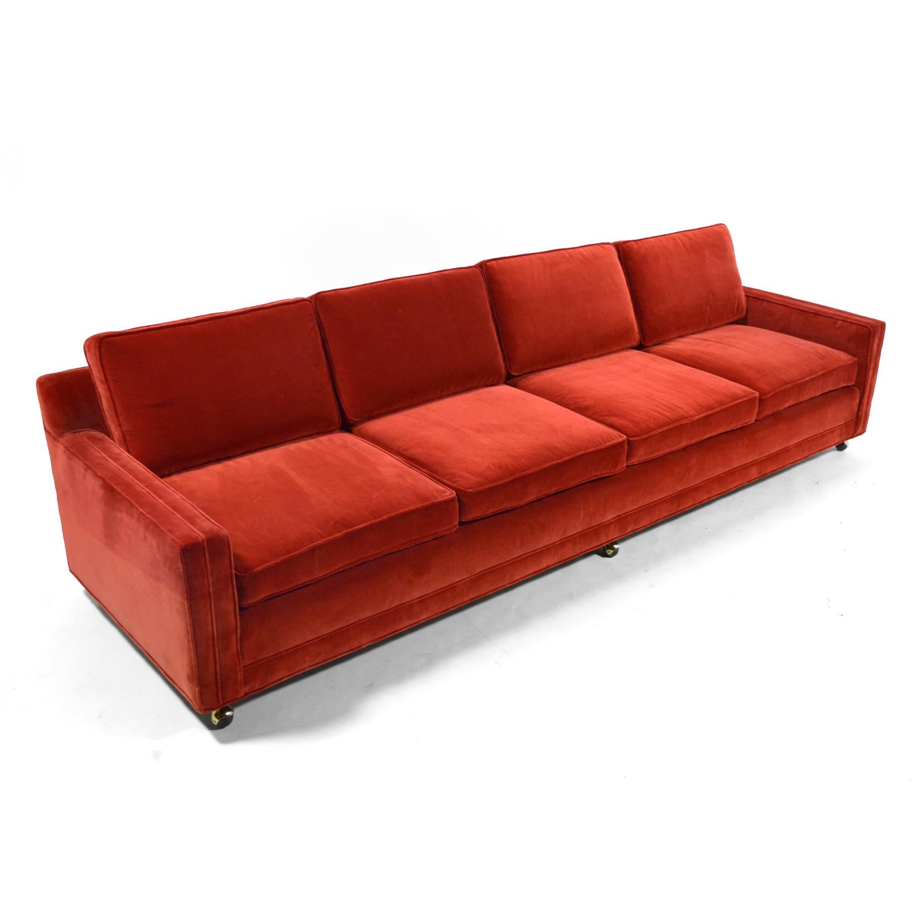 This double arm sofa is Classic Harvey Probber. Impeccably proportioned with great details, the extra long sofa has a timeless rectilinear design with four seats, each with a loose seat and back cushion. It is supported by stubby legs with ball