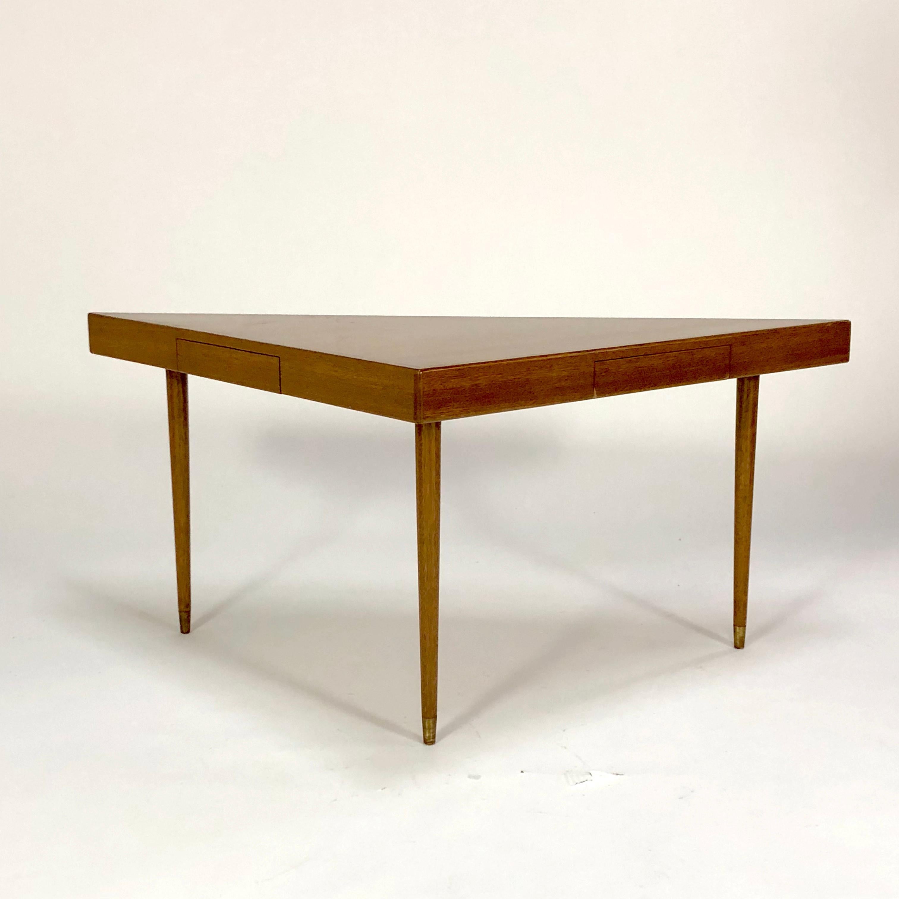 A console table of mahogany. Drawers slide out from both of the shorter sides of the triangle. Marked by the manufacturer.