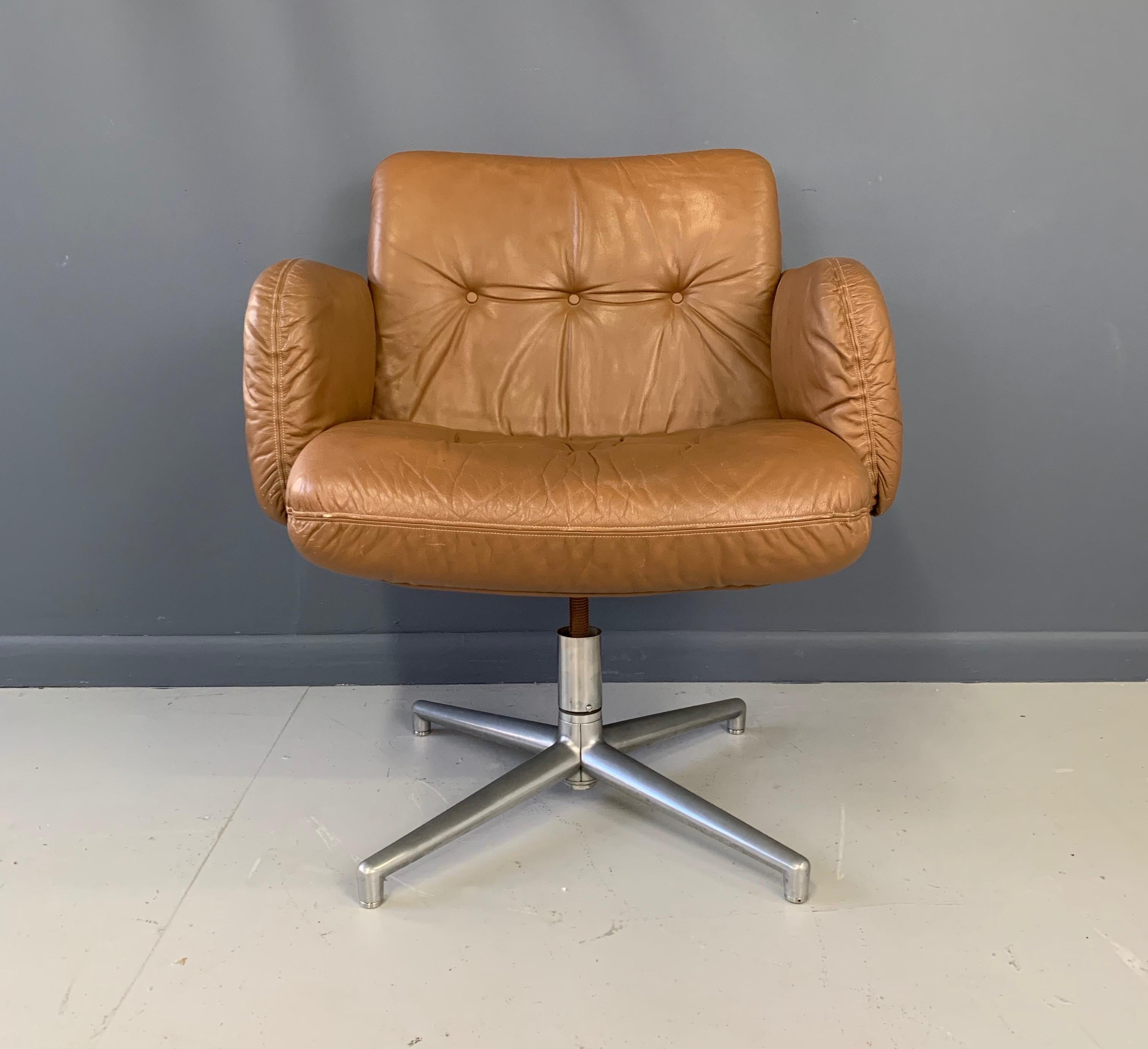 This beautiful chair covered in tan leather has a three button back and armrests it swivels on its aluminum base. This chair has been lovingly worn in and the leather is soft and supple showing minimal wear.
         