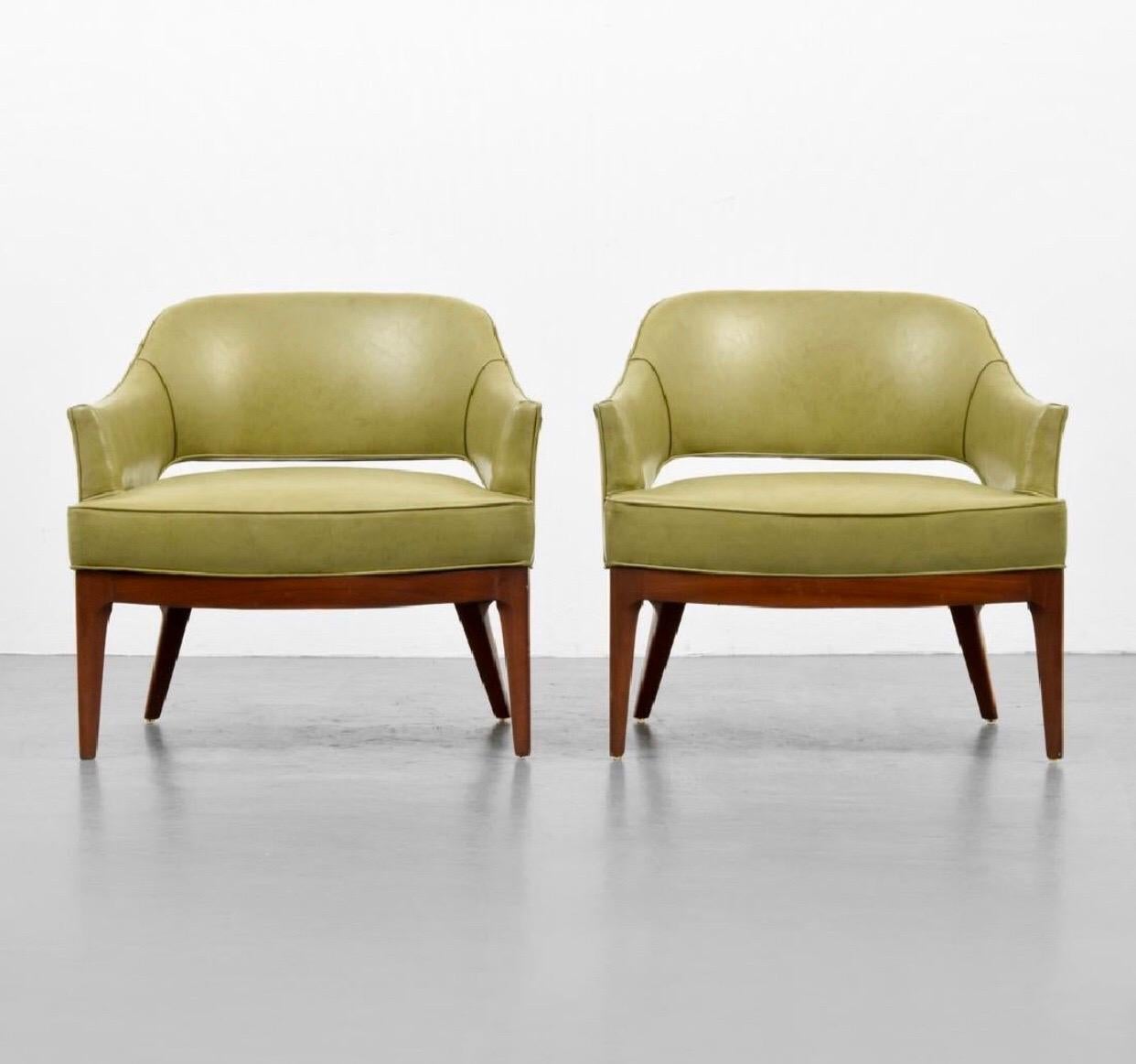 Mid-Century Modern low slung club chairs by Harvey Probber. Chairs feature sculpted walnut legs with a curved front, and stunning original green Naugahyde. On the inside of one leg towards the top of the leg there is a chip in the wood. (not