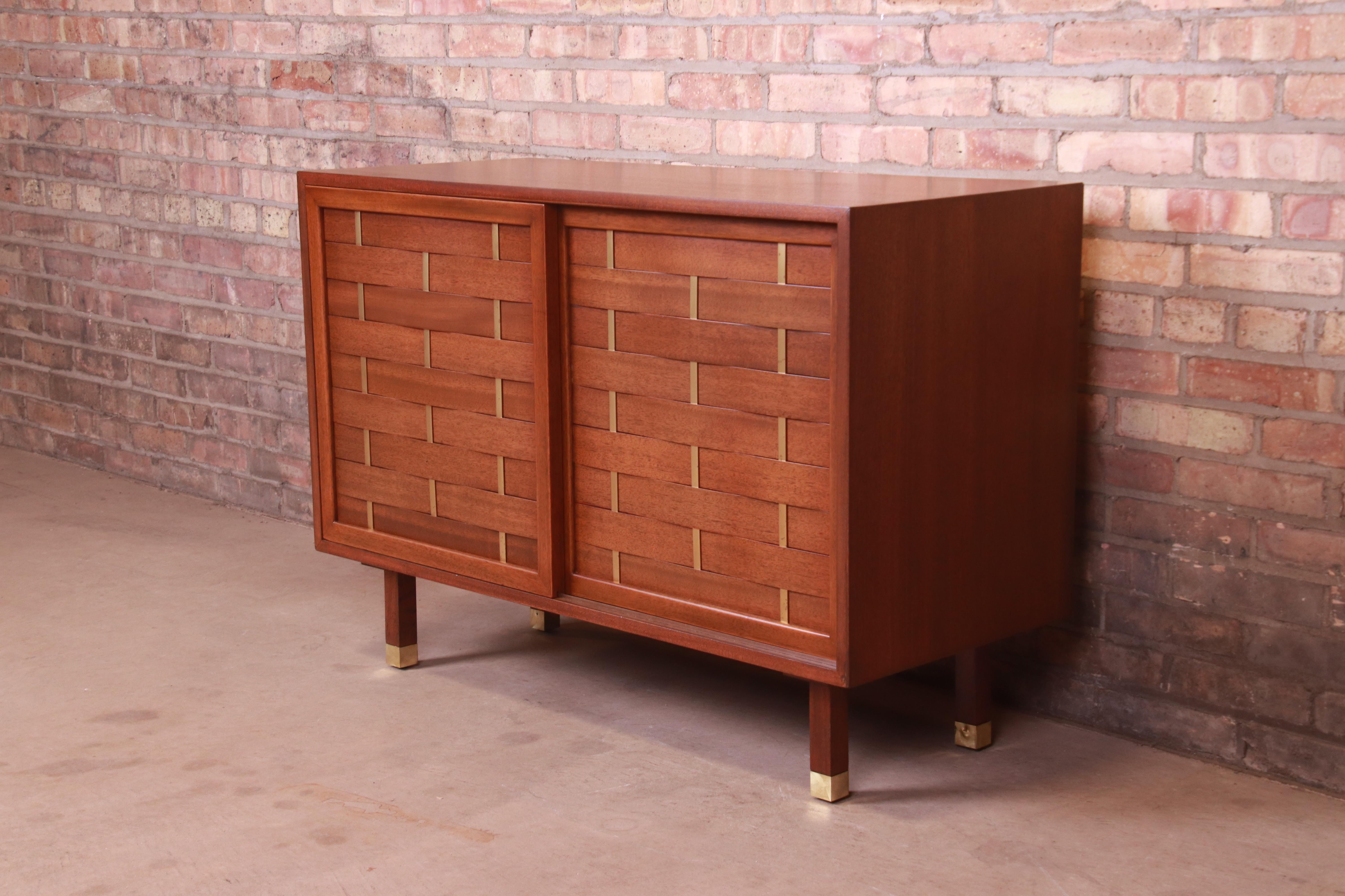 An exceptional Mid-Century Modern woven front sliding door credenza or cabinet

By Harvey Probber

USA, 1960s

Mahogany, with brass accents and brass-capped feet.

Measures: 42
