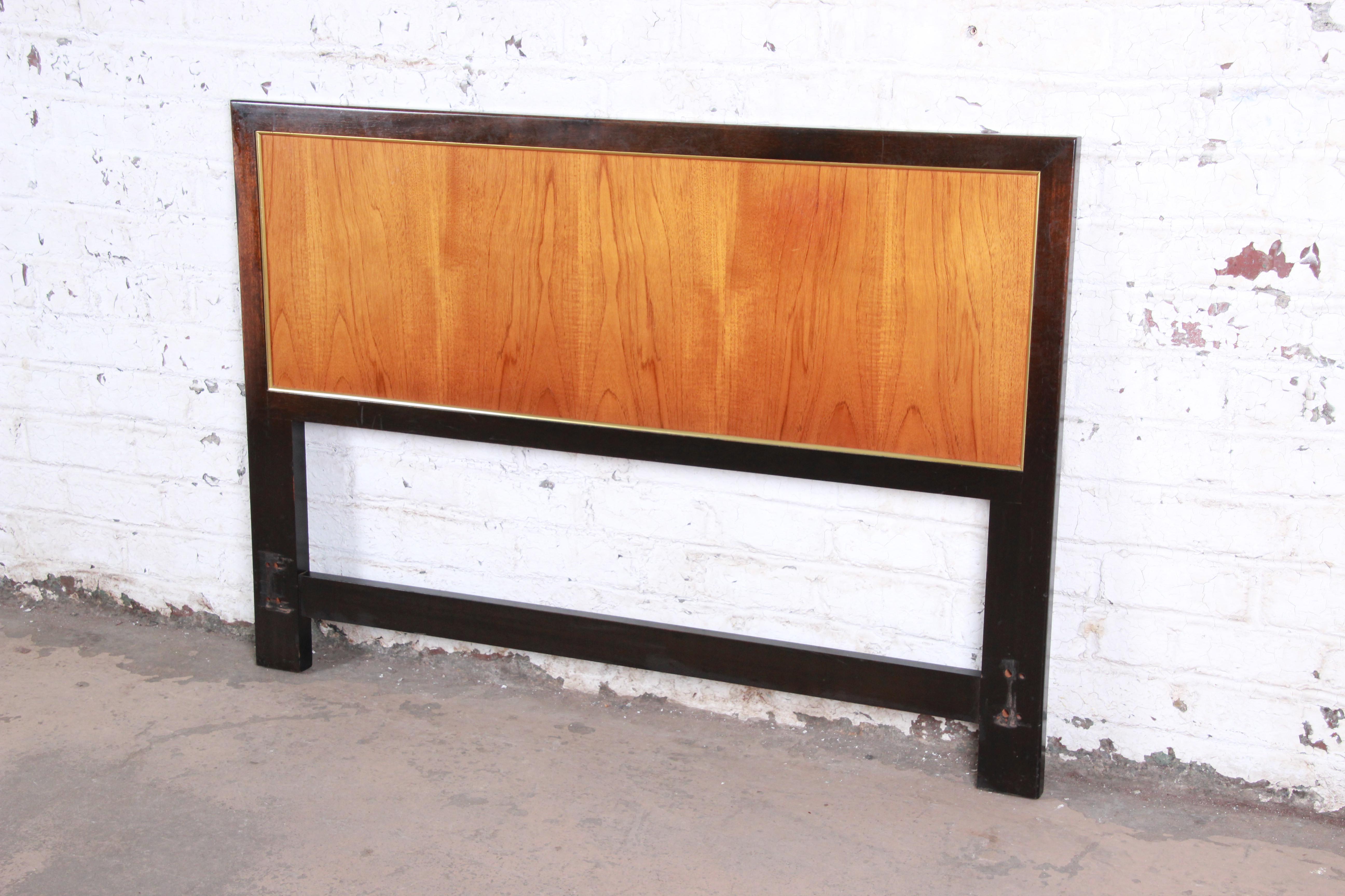 An elegant Mid-Century Modern full size headboard designed by Harvey Probber, circa 1960. The headboard features gorgeous teak wood grain framed in mahogany with brass trim. A beautiful example of Probber's iconic design work. The headboard is in