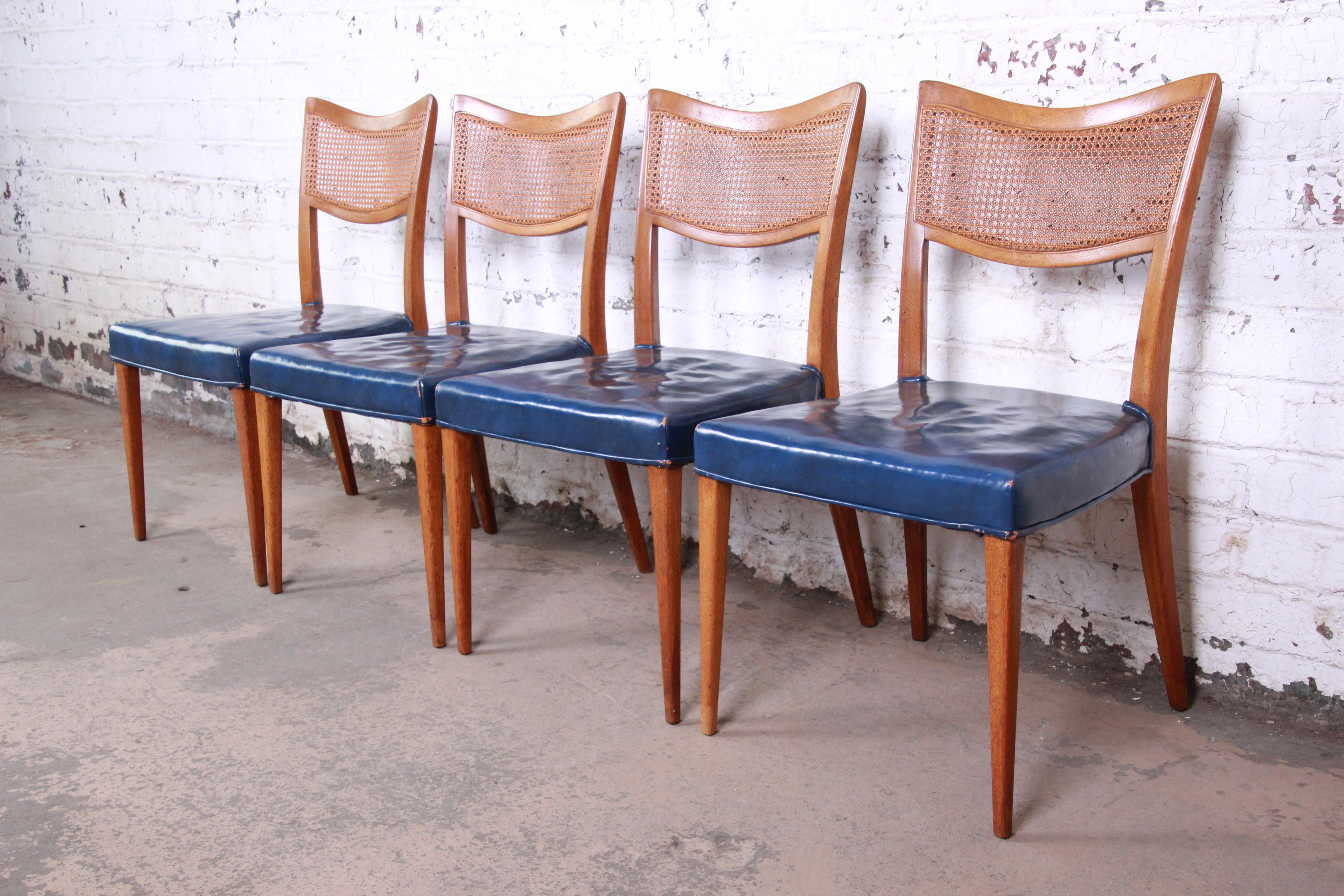 A gorgeous set of four Mid-Century Modern dining chairs by Harvey Probber. The chairs feature sleek solid mahogany frames with curved caned seat backs. Very similar to designs by Paul McCobb. The original upholstery shows wear, and there is some