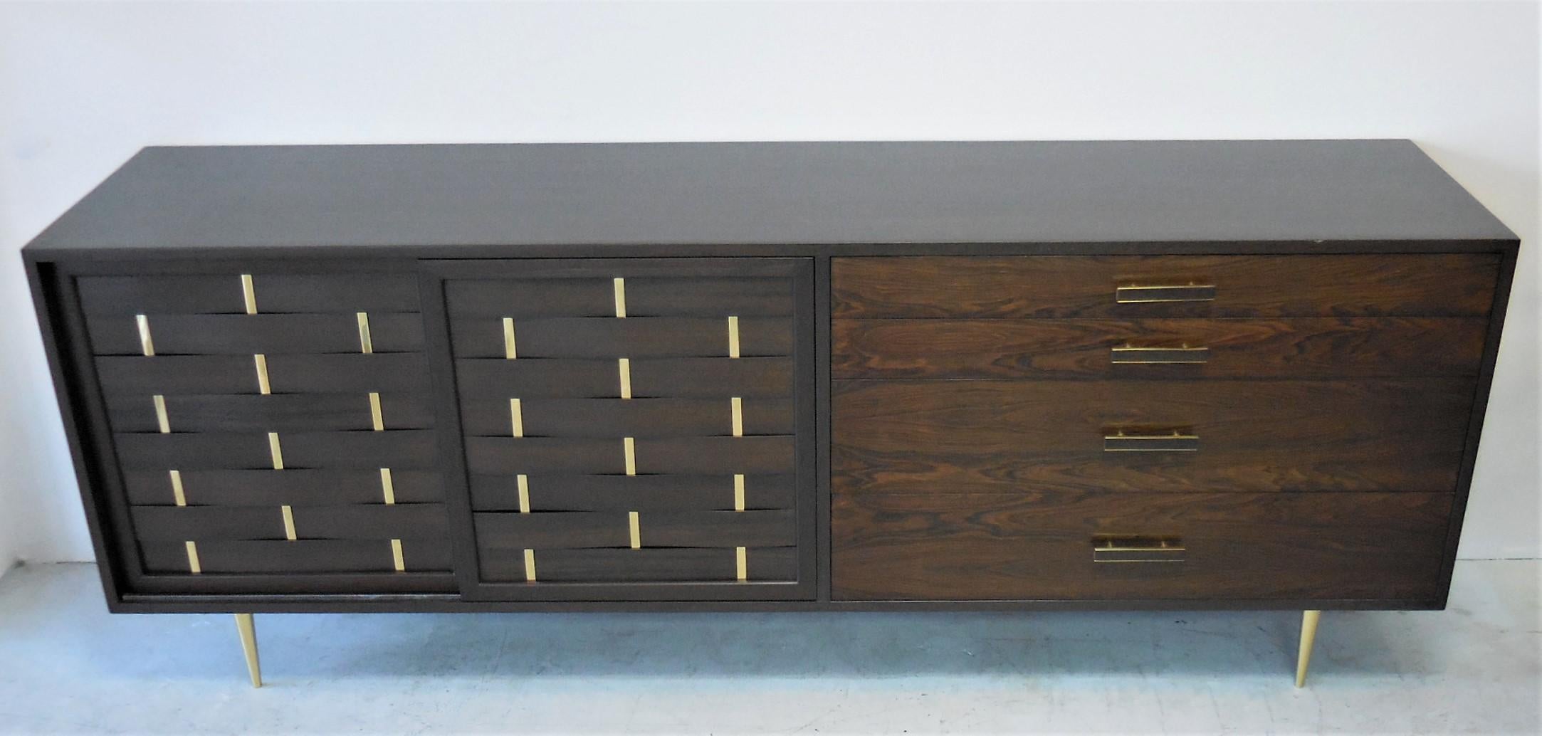 Exquisite midcentury sideboard or console by Harvey Probber. The simple but well proportioned design is accented by brass elements positioned in the right places. Two webbed wood and brass doors conceal 4 sliding trays lined with cork. Four drawers