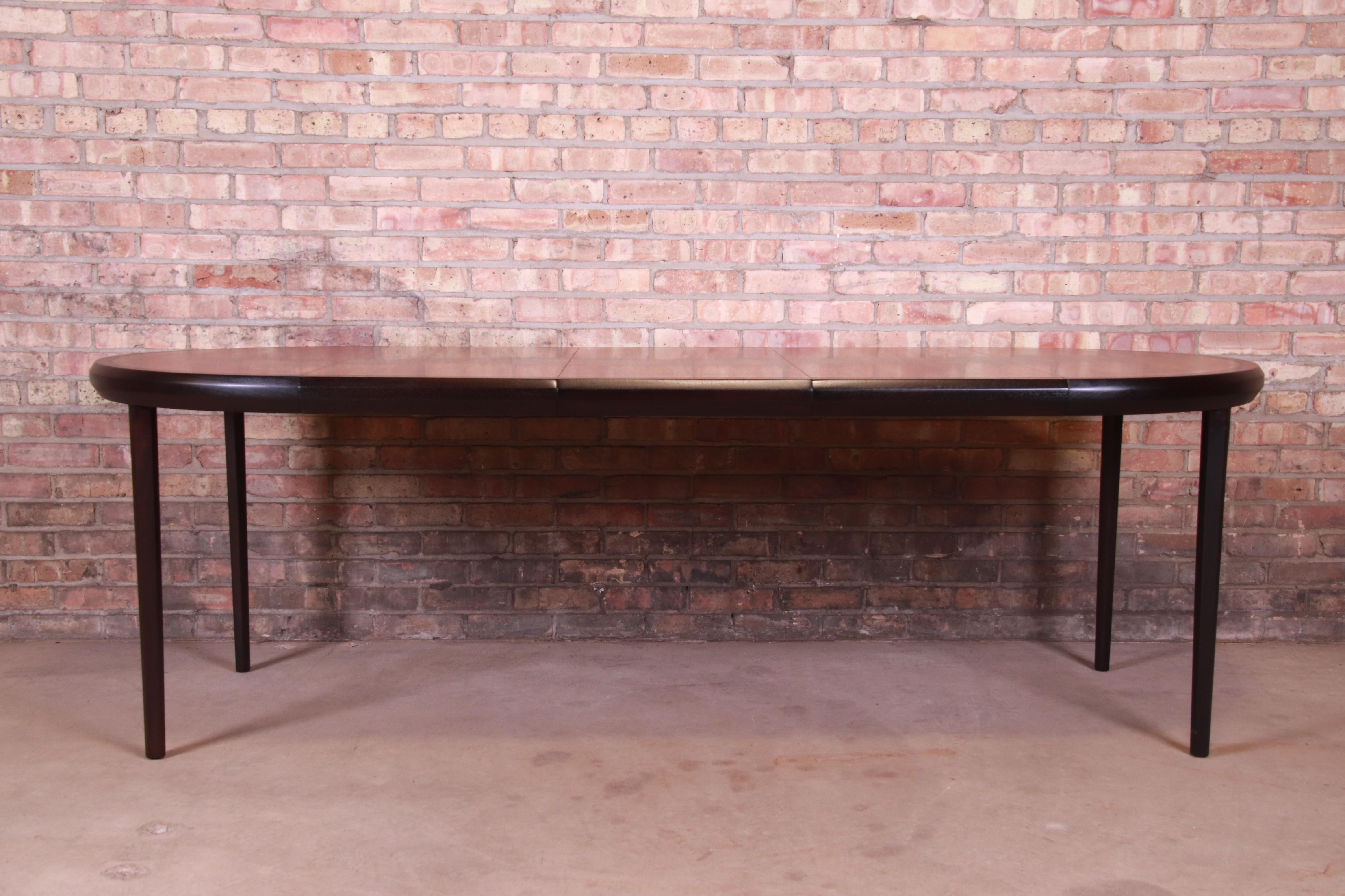 An exceptional Mid-Century Modern extension dining table

By Harvey Probber

USA, 1950s

Book-matched rosewood top, with ebonized walnut banding and legs.

Measures: 38