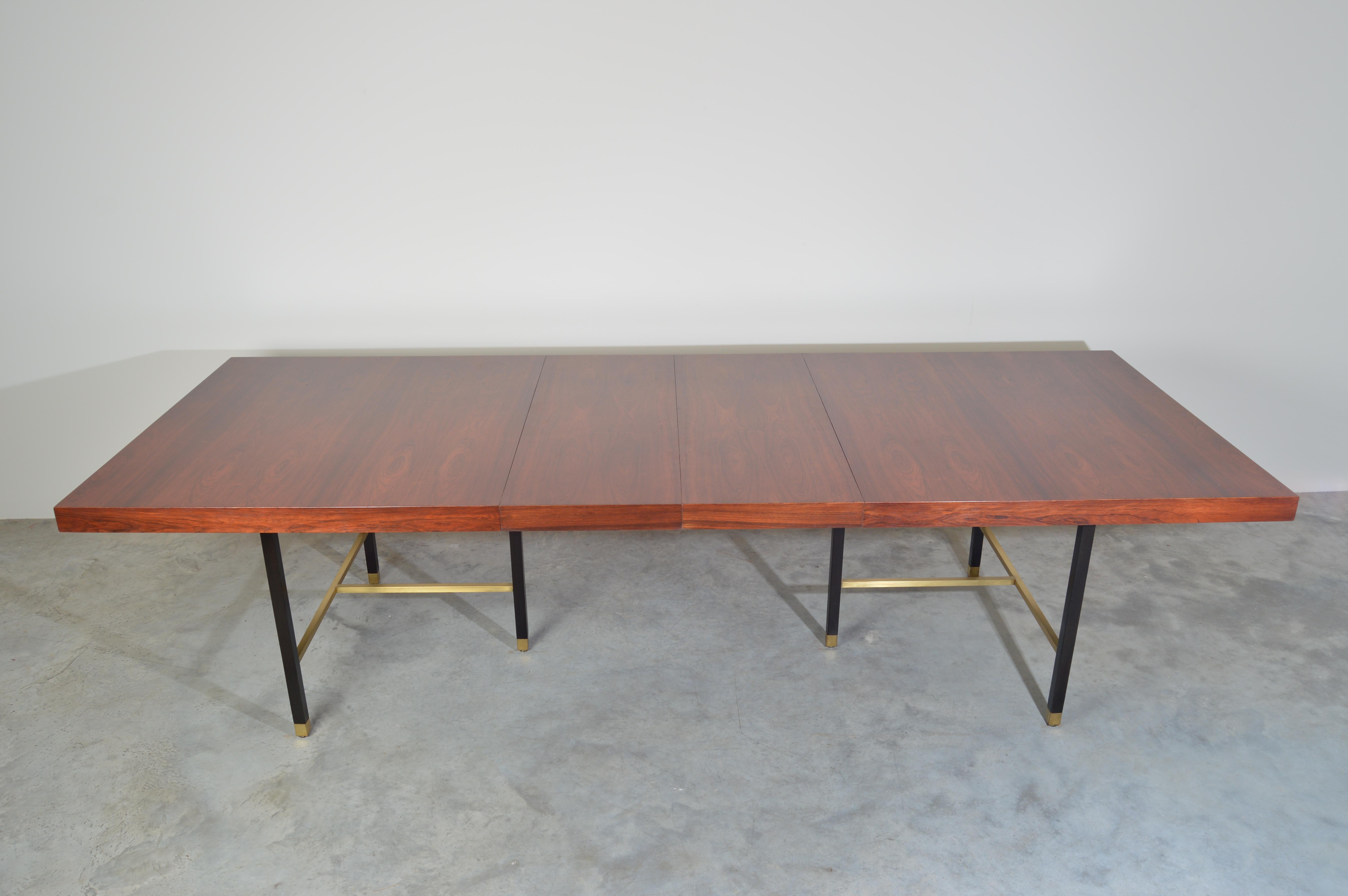 A stunningly elegant expandable dining table in rosewood having mahogany and cast iron legs with brass accents throughout. Designed by American post-war designer Harvey Probber, circa 1950.
Two 16” leaves expand the table from 80” to 112” in
