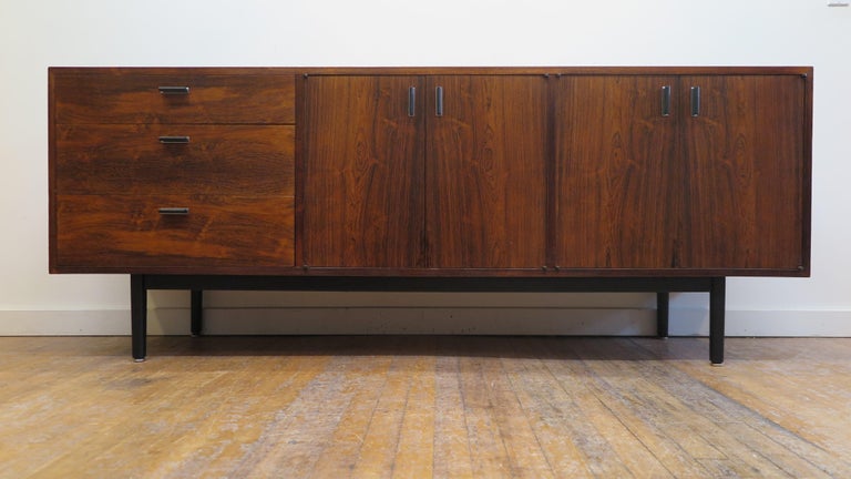 Harvey Probber rosewood sideboard credenza. Brazilian rosewood sideboard credenza having three drawers and two cabinets.  The Rosewood has a richness in color and grain that defines the minimal elegance of this design. Top drawer has defined