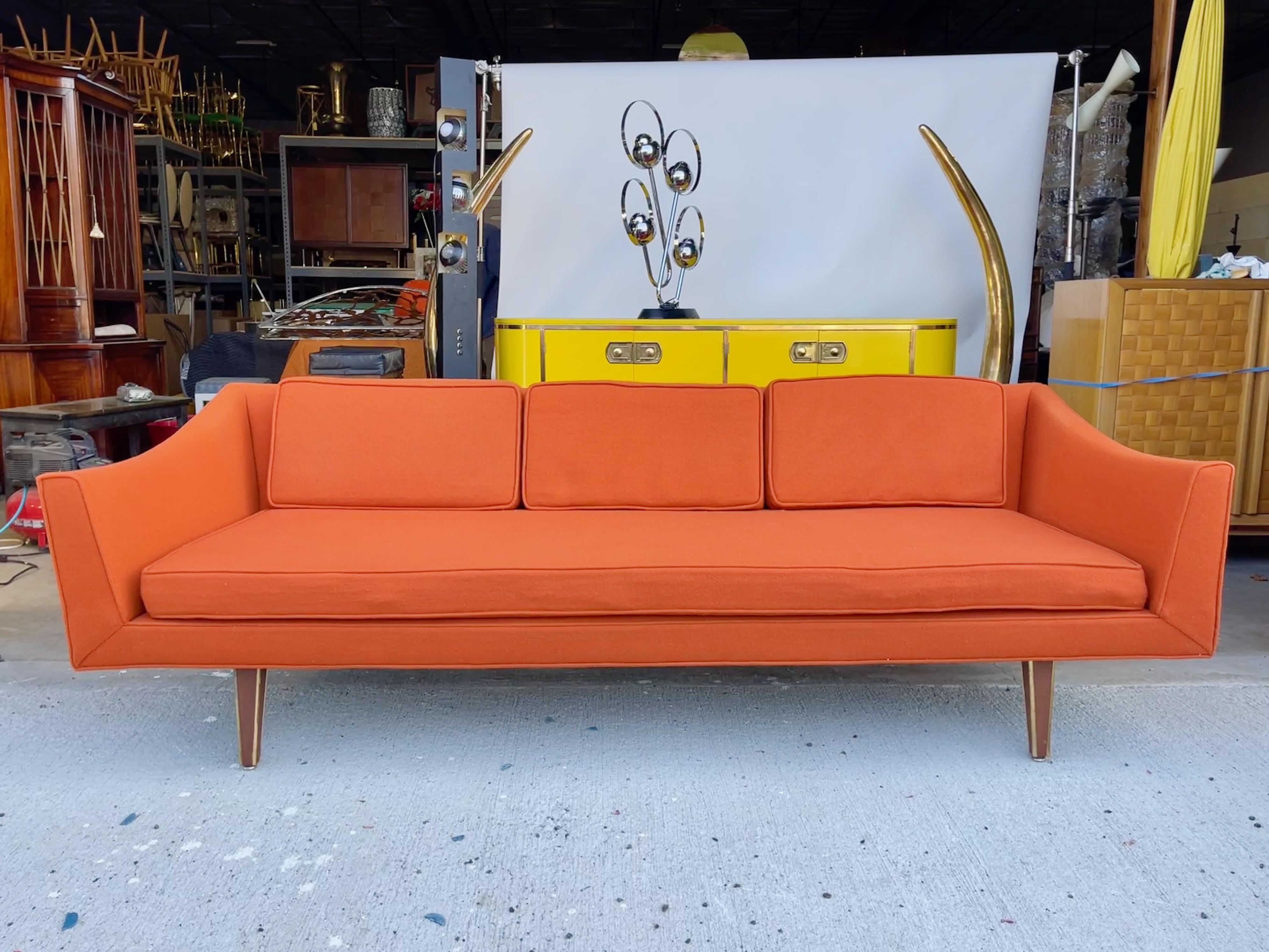 At last, a mid-century sofa at a comfortable seat height thanks to its 10 inch high legs.
Original Harvey Probber mid-century modern sofa with distinctive sloped arms and square tapered walnut legs embellished with solid brass vertical corner