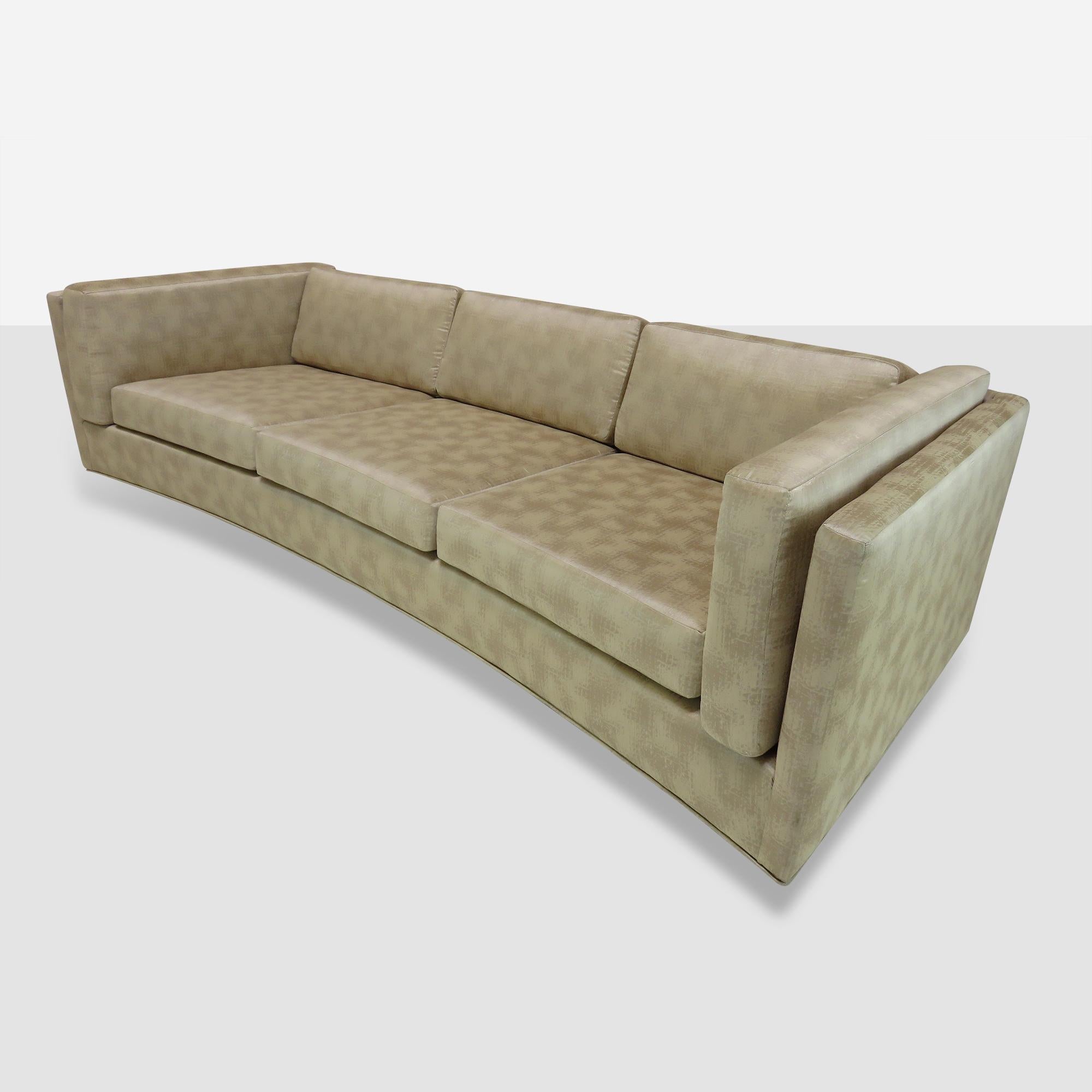 A three-seat sofa by Harvey Probber. Curved front. Loose cushions on the seat, back and sides. Sofa sits on 6 wooden feet.