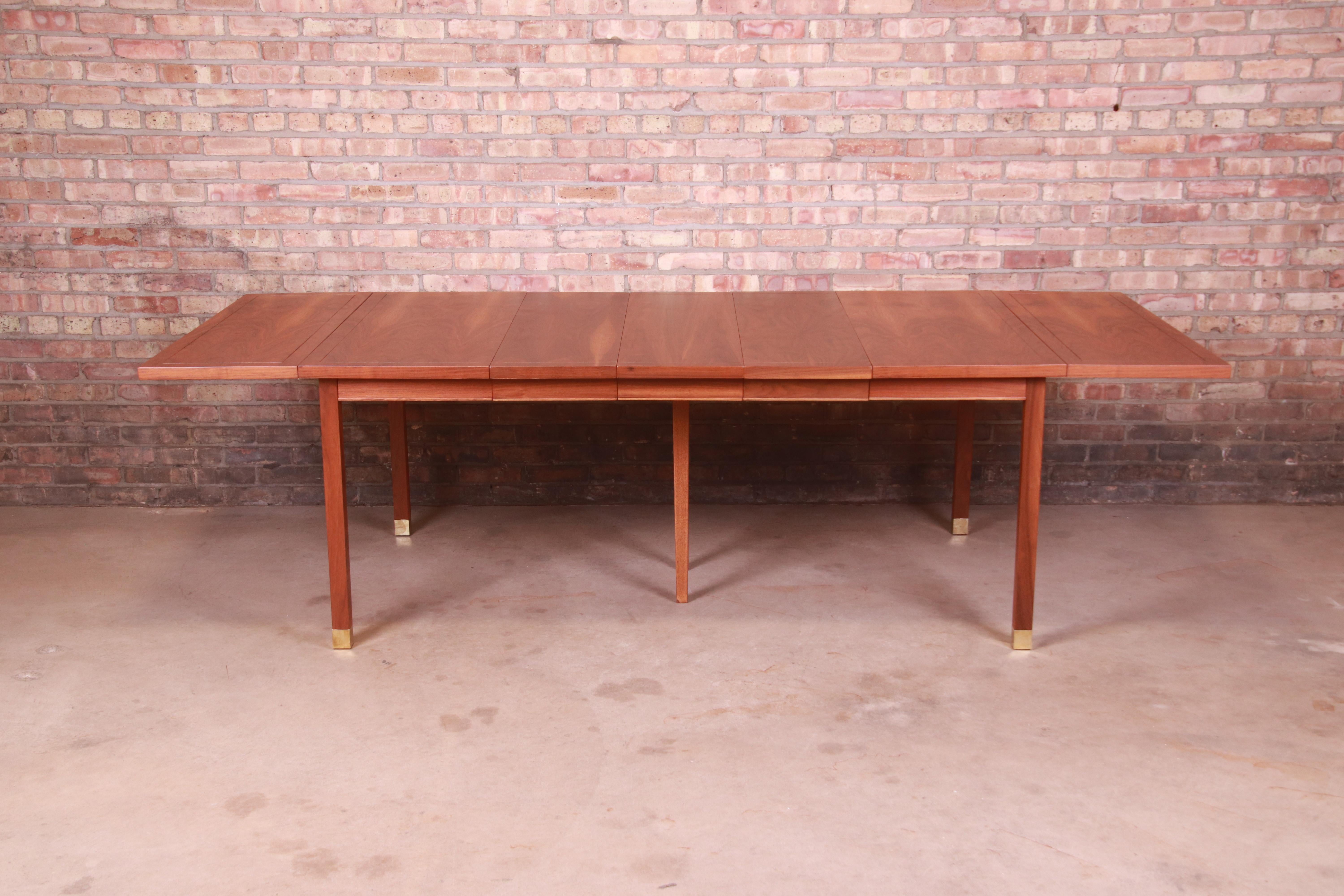 A stunning Mid-Century Modern drop leaf extension dining table

In the manner of Harvey Probber

USA, 1960s

Gorgeous figured walnut top, with solid walnut legs and brass-capped feet.

Measures: 102