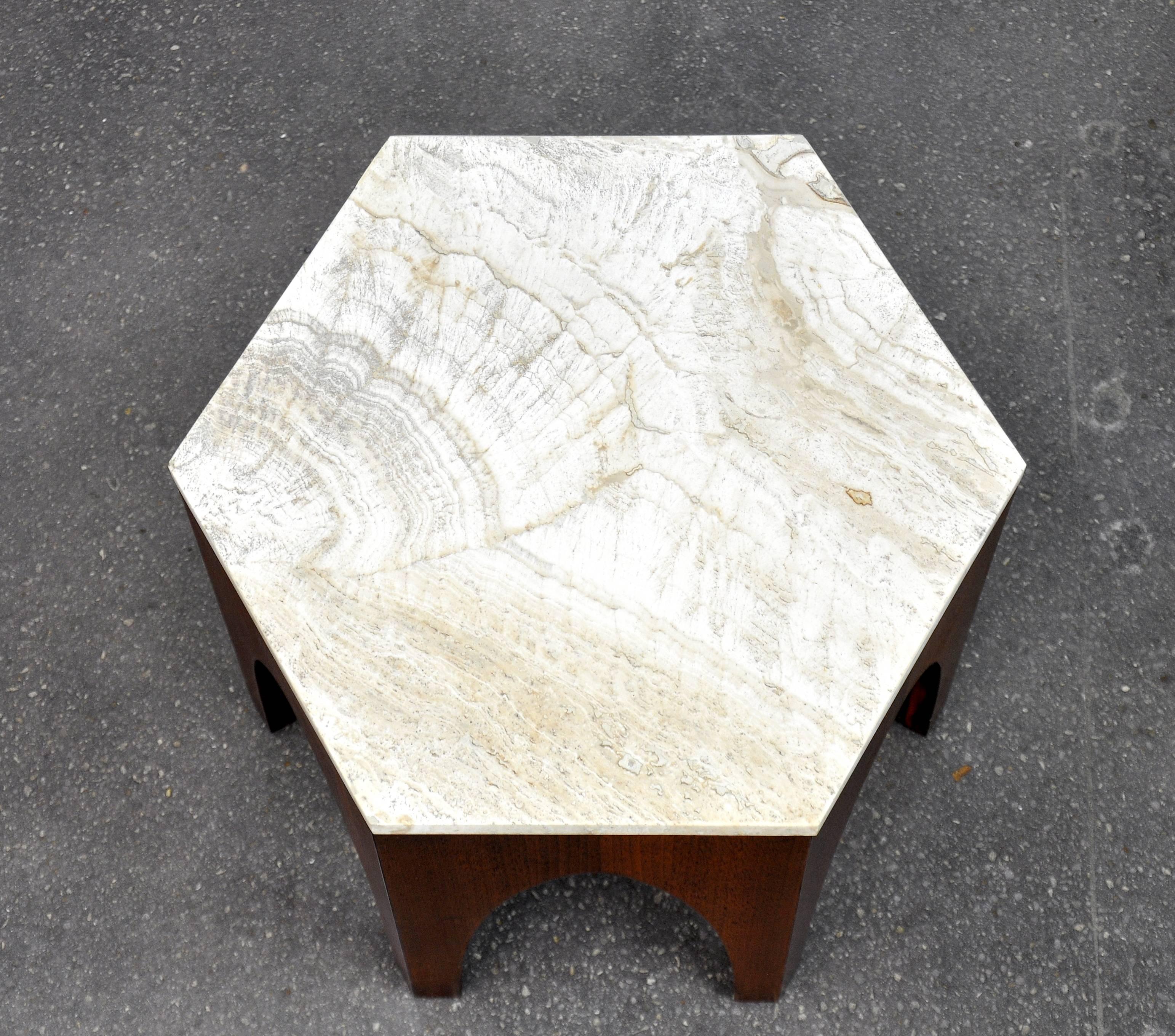 A great 1960s Mid-Century Modern end or occasional hexagon table designed by Harvey Probber. It features an Italian travertine inset top over a walnut base with Moroccan inspired arches. Being finished on all sides, it could also be used as a plant