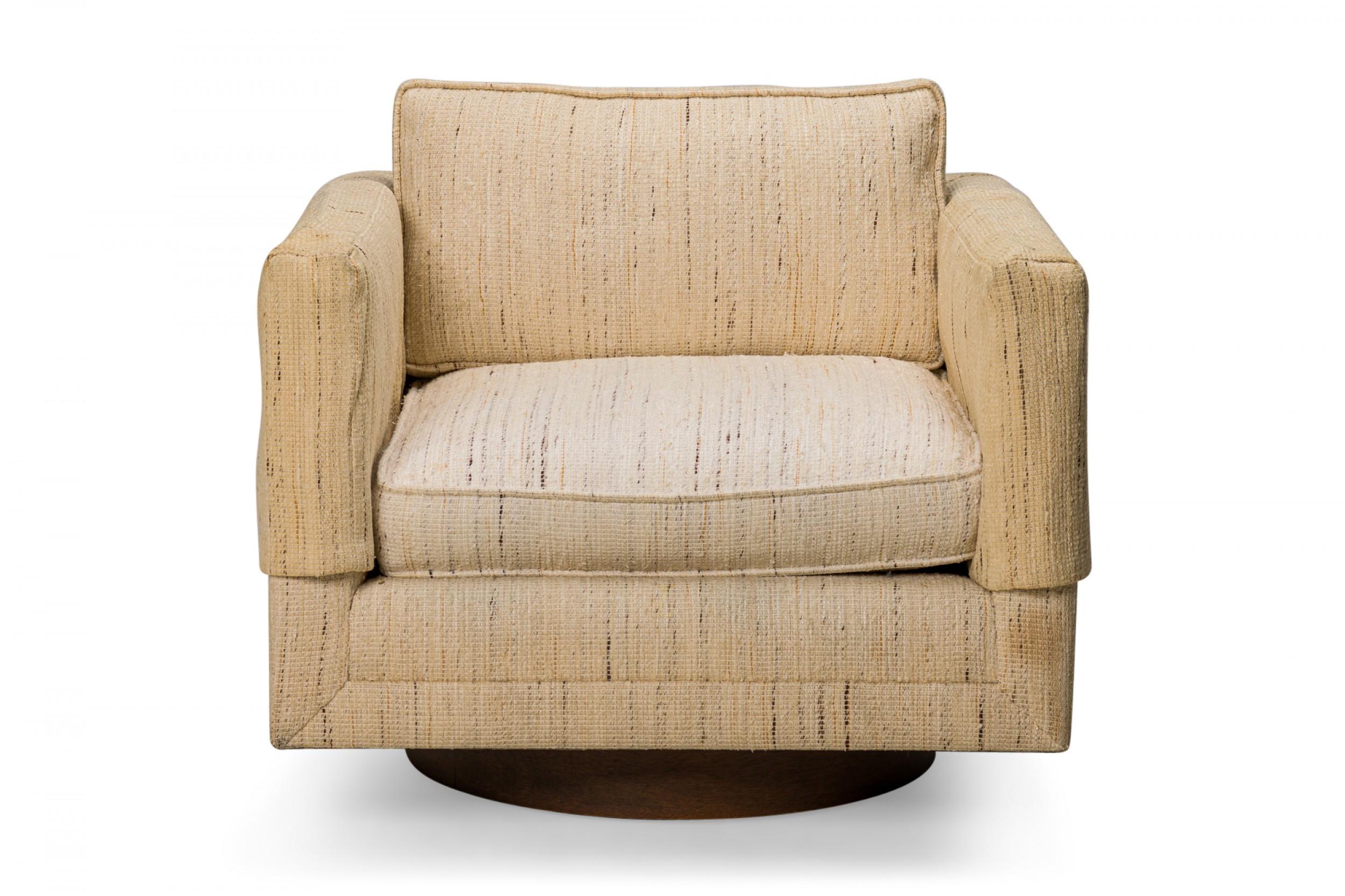 American Mid-Century swiveling cube form lounge / armchair with textured woven beige fabric upholstery and matching antimacassars. (HARVEY PROBBER)
