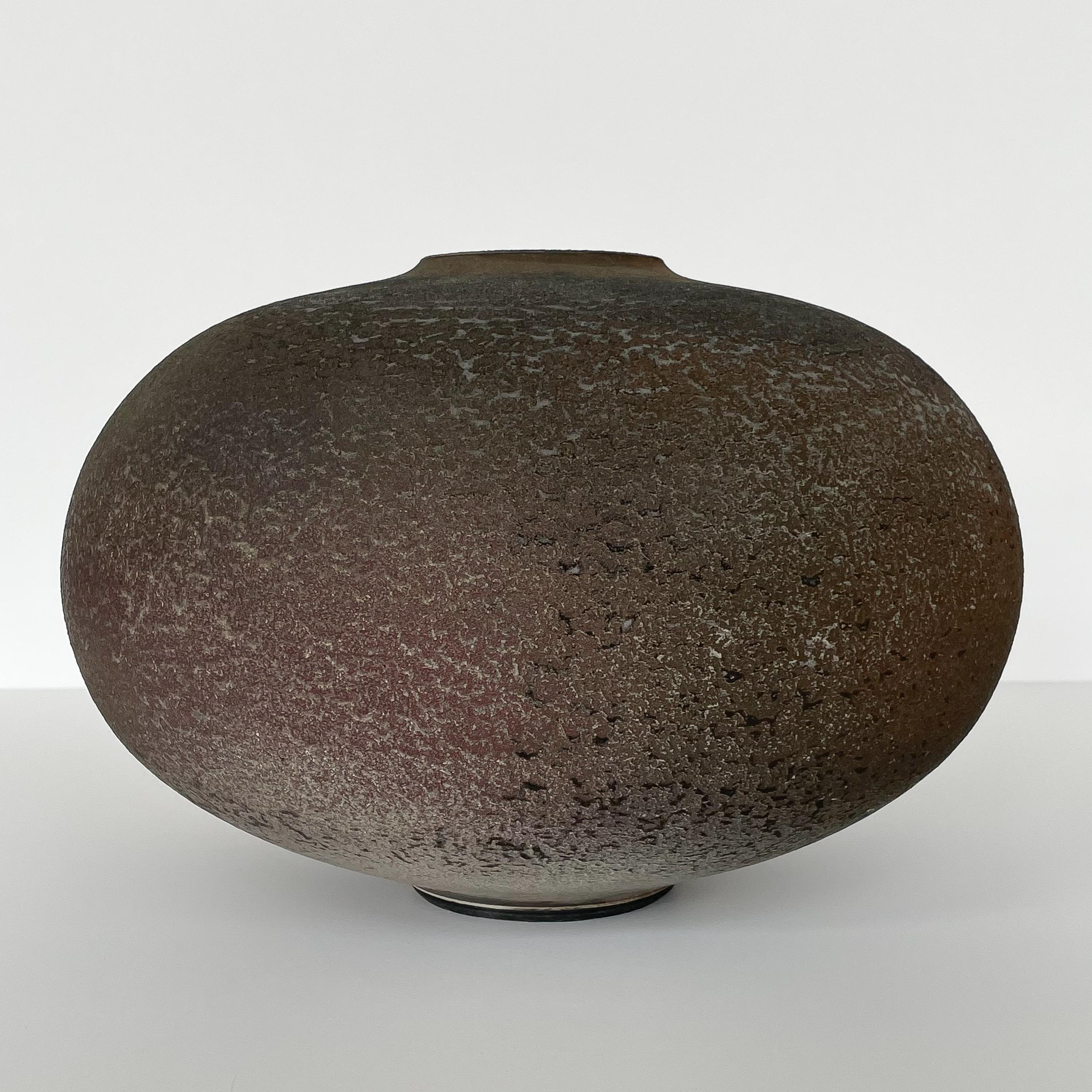 Raku fired stoneware vessel by Harvey Sadow (American, b. 1946), circa 1984. This hand thrown ceramic vase features a textural glaze in rust, gray and earthtones. Inscribed H. Sadow, Maryland 1984. Measures: 8.5