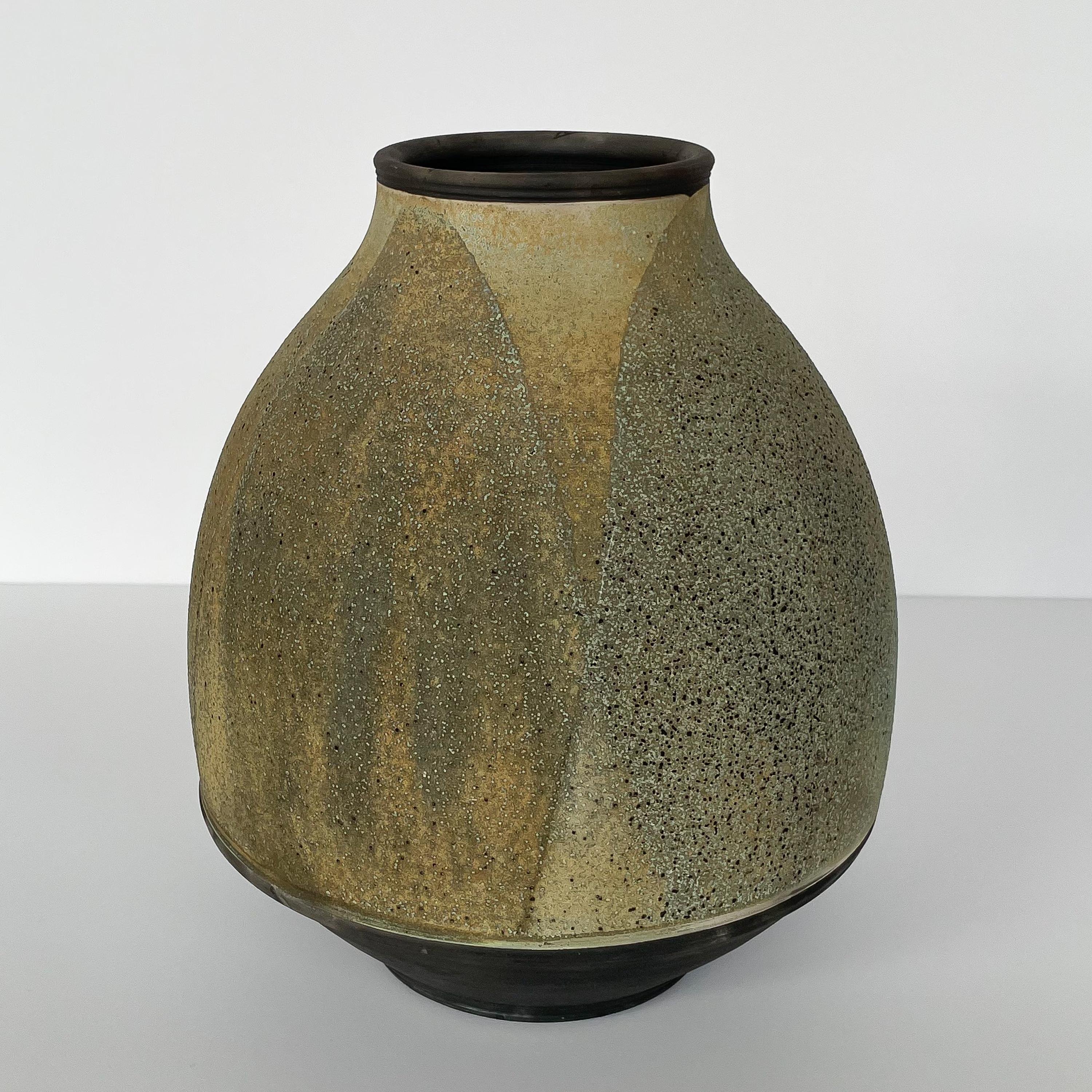 Raku fired stoneware vessel by Harvey Sadow (American, b. 1946), circa 1980s. This hand thrown ceramic vase features an abstract layered leaf-like design in pale greens and earthtones. Textured exterior glaze. Artist insignia to underside. Measures: