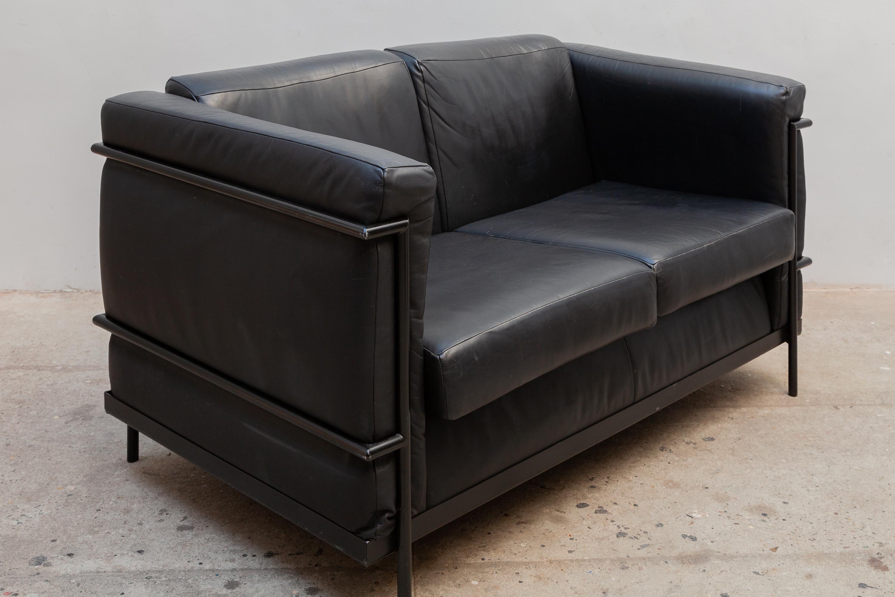 Original Harvink sofa inspired by Le Corbusier LC2. Black metal tube frame with black leather upholstery in loose cushions for a cozy seat. Dimensions: 140 W x 76 H x 80 D cm seat 45cm high.