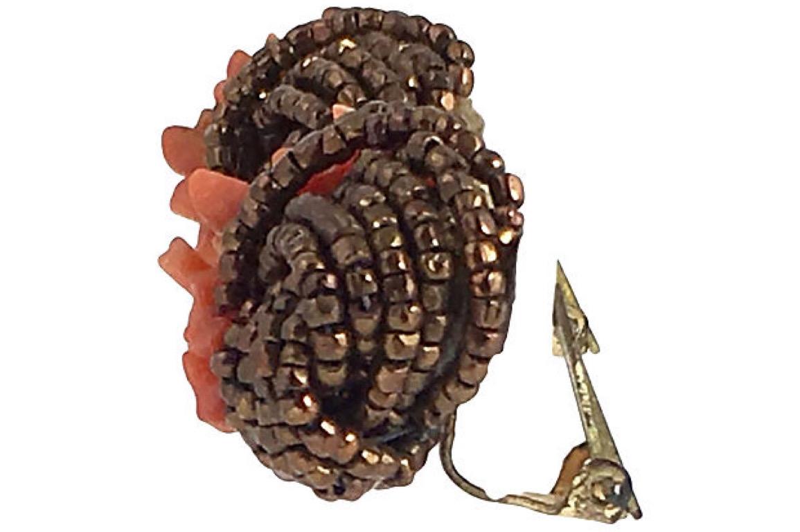 Haskell-Ohrringe im Stil der Jahrhundertwende aus Kunstkoralle und bronzefarbenen Glasperlen mit Clip-Back-Knoten. Keine Herstellermarke. Altersbedingte Abnutzung, Anlaufen auf den Rückseiten.
