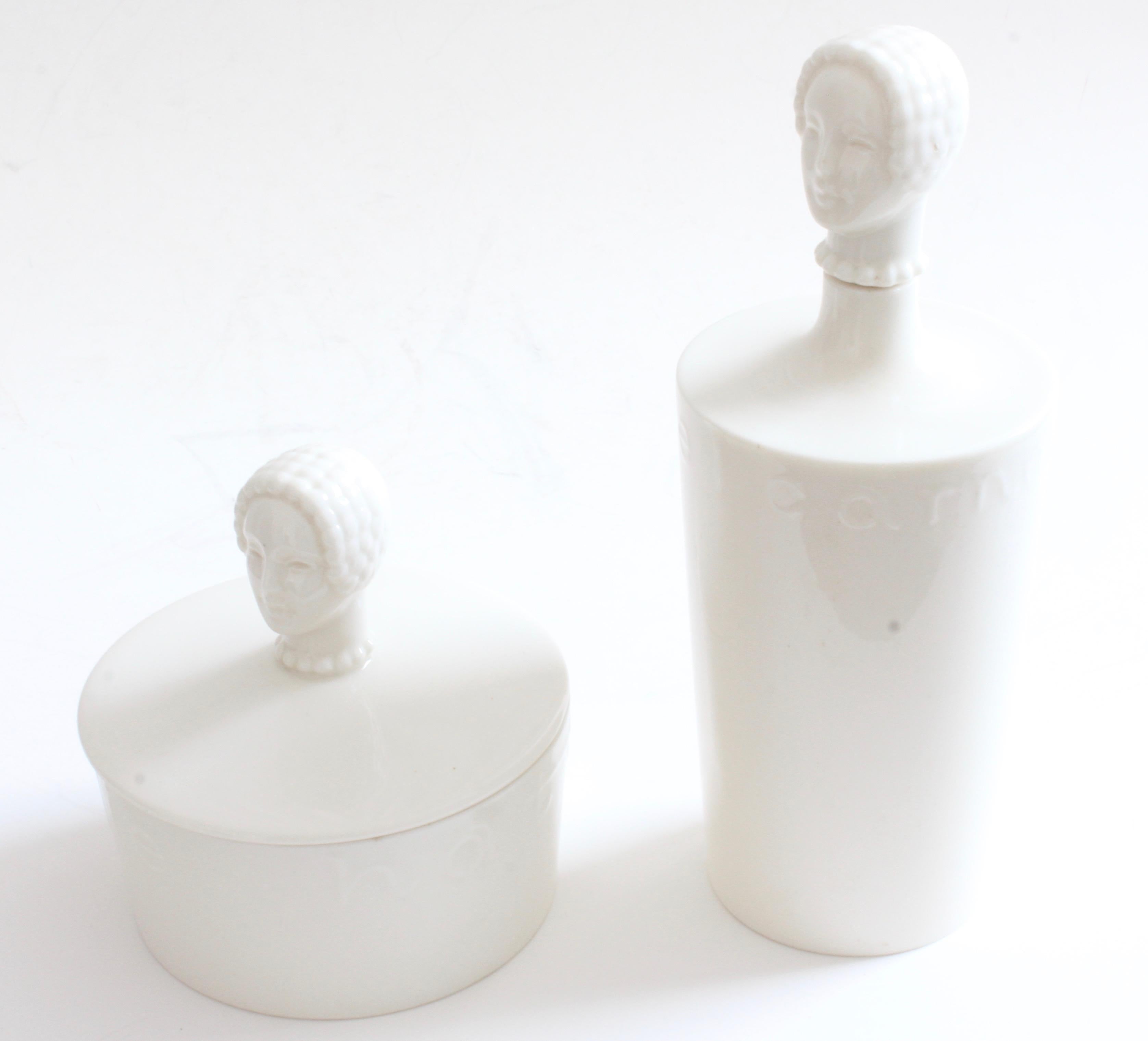 Ponemos a tu consideración un raro juego de polvera y decantador de loción de porcelana, creado para Hattie Carnegie por Lenox, probablemente a finales de la década de 1940.  Ambas piezas presentan una figura en la parte superior y letras en relieve