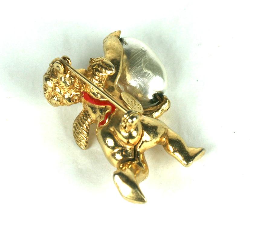 Hattie Carnegie cherub brooch clutching an large oval faux baroque pearl. The  three dimensional cherub is made of gilt metal with a red cold enamel detailed sash.
Excellent Condition.  Signed
Length  1  5/8