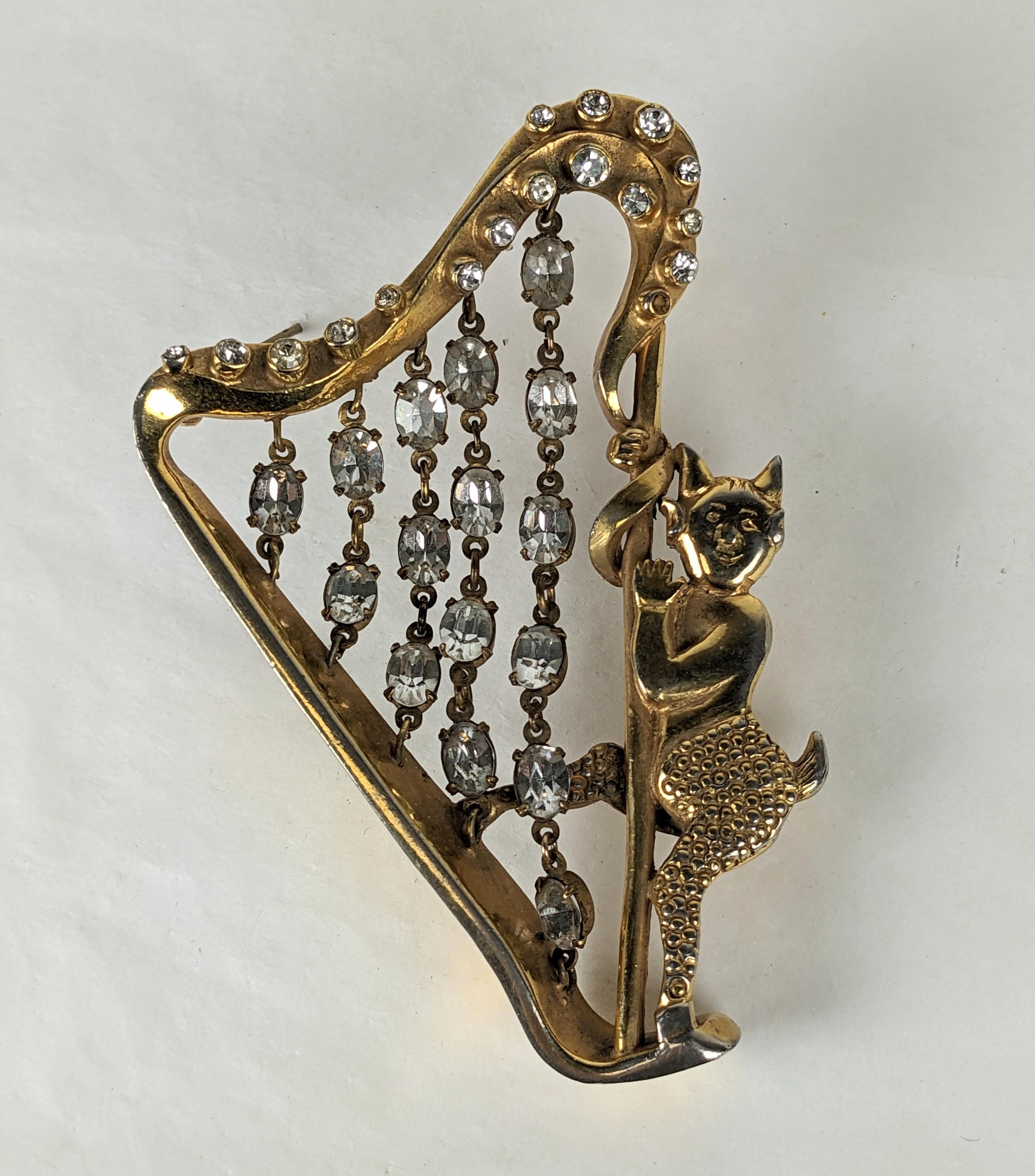 Charming Hattie Carnegie Mischievious Devil playing Jeweled Harp Strings brooch from the Art Deco era. Novelty brooches were all the rage in the 1930's and 40's and Hattie Carnegie created many iconic designs. 
This piece is unsigned. Super rare and