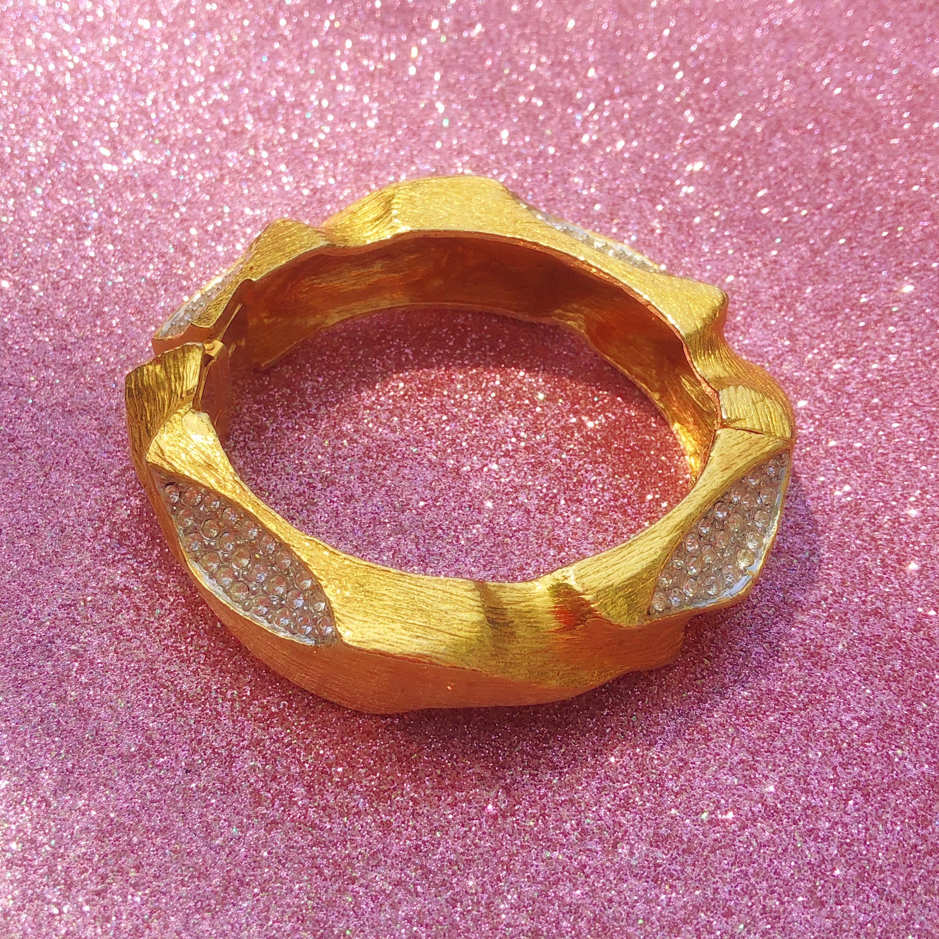 Gorgeous and rare gilded rhinestone pavé chunky clamper bangle bracelet by iconic jewelry brand, Hattie Carnegie. 

In 1918, Hattie Carnegie Inc. was founded, starting with a full-scale clothing line. In 1939, Hattie Carnegie began producing jewelry