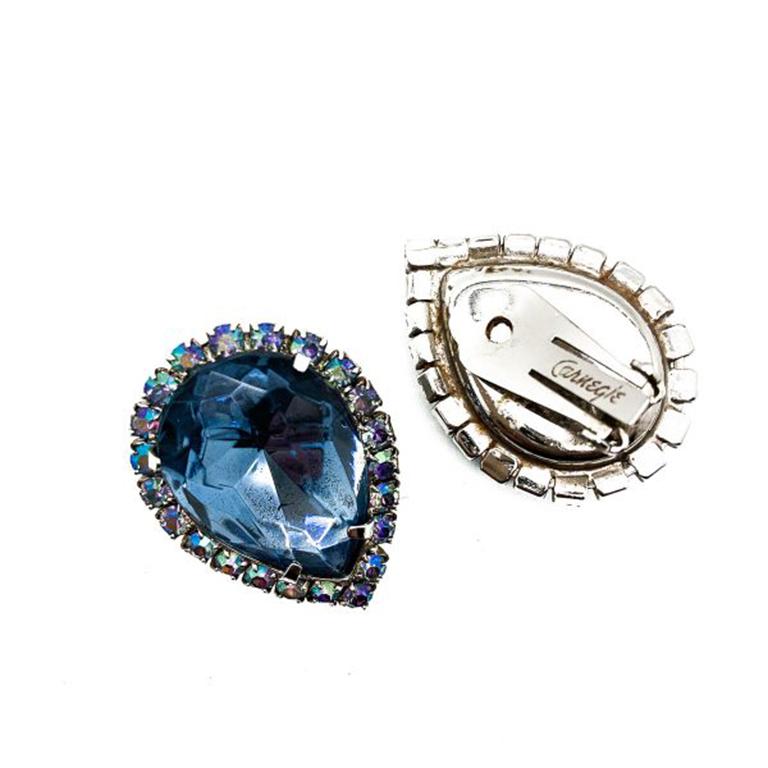 A super pair of Hattie Carnegie Earrings hailing from the 1950s. These clip on Hattie Carnegie Earrings feature a stunning pale blue crystal teardrop surrounded by blue aurora borealis crystals all set in a silver-tone setting. The earrings measure