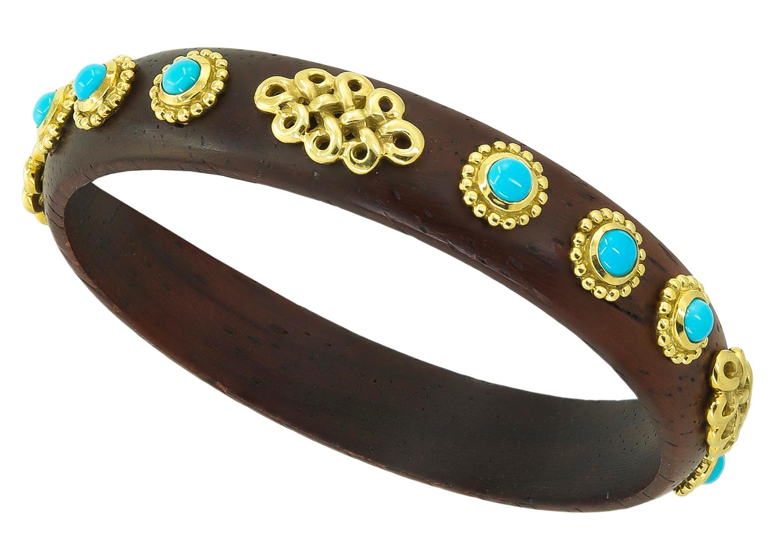 Haume Wood Turquoise Bangle Bracelet in 18k Yellow Gold.
A wood bangle bracelet embellished with gold and turquoise by Adria de Haume. The dark wood resembles cocobolo or similar knotted hard reddish-brown wood, with a slightly oiled patina.