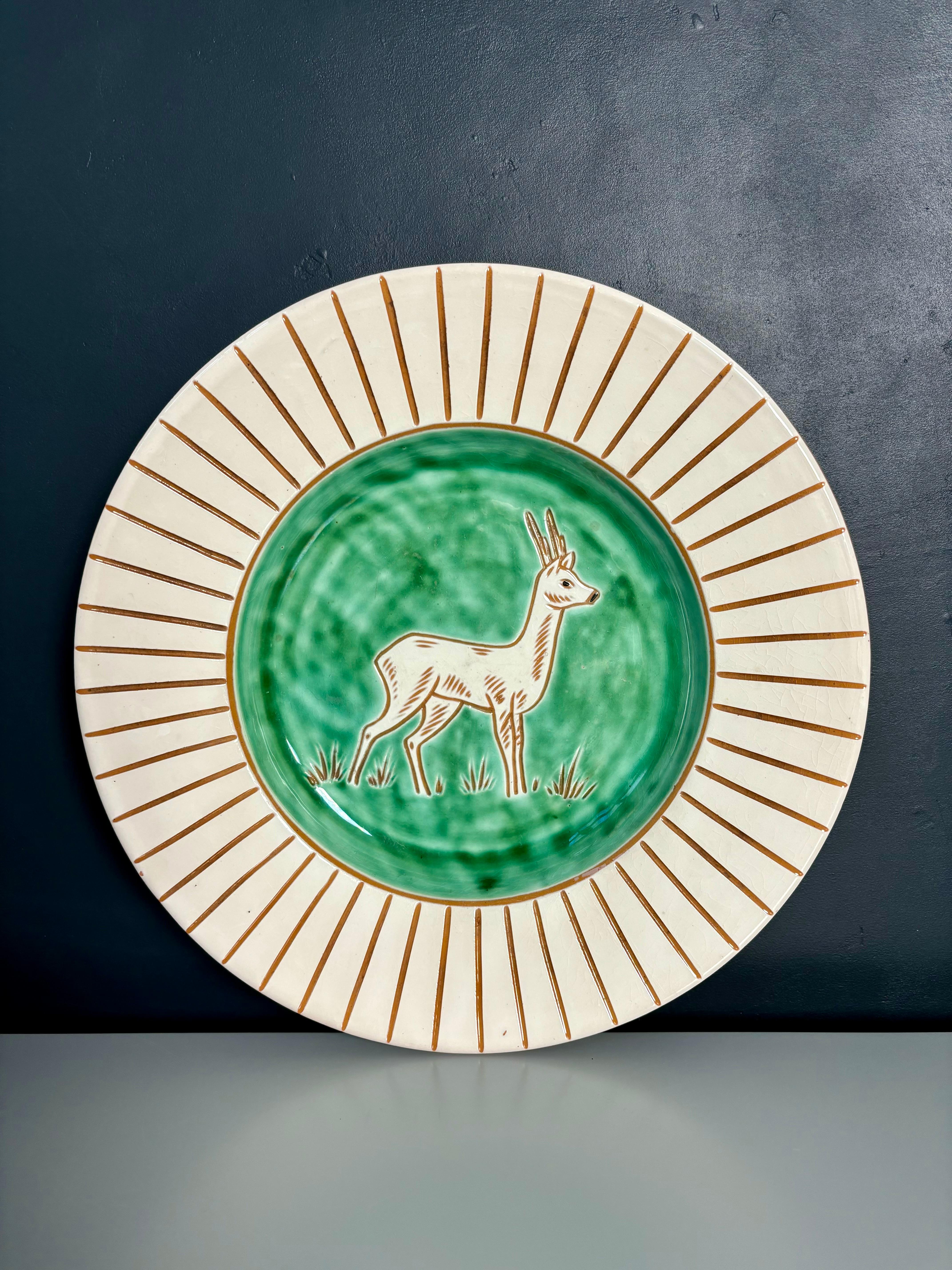 Scandinavian modern decorative ceramic dish made by Haunsø Ceramics in the 1950s. Shiny cream white and bright green glazed plate with incised symmetrical lines and depiction of a deer as the main motif. Signed under base.
Beautiful vintage