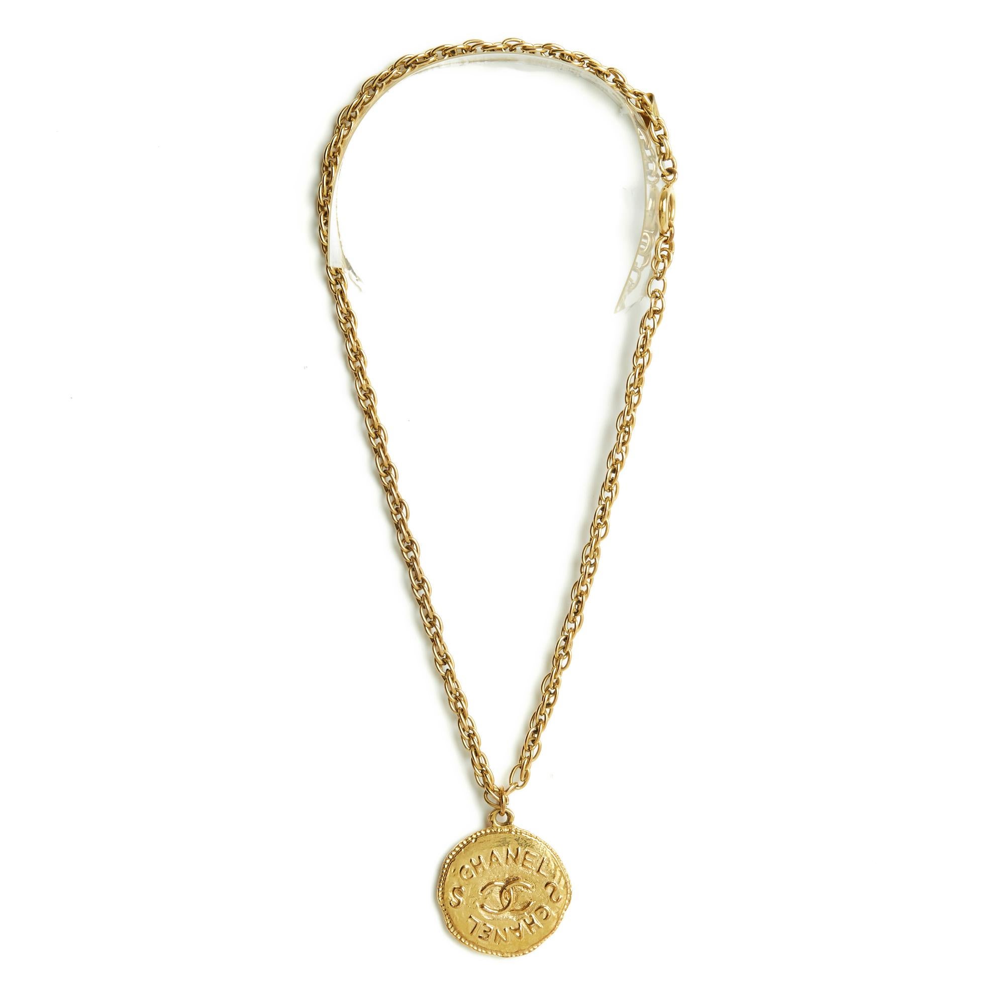 Chanel Haute Couture necklace in gold metal composed of a twisted mesh chain and a large medallion shaped with the motif of the CC logo. Total length of the chain (open) 43 cm, diameter of the medallion 3.35 cm. The necklace is vintage, in very good