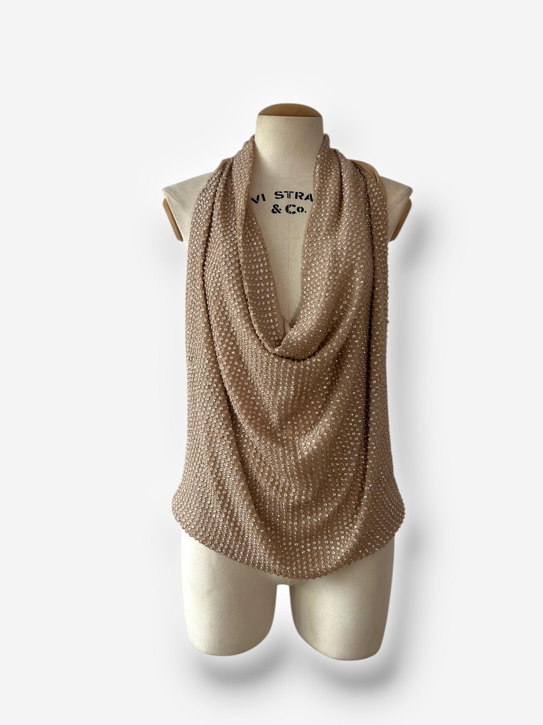 

Glamuroso y fluido, este top vintage sin mangas Haute Hippie está totalmente adornado a mano con abalorios brillantes sobre una suave base 100% seda en tono nude. El escote de pico drapeado y la profunda espalda redondeada crean una silueta