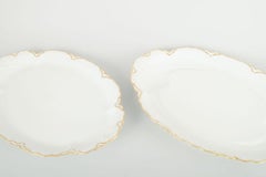 Haviland, France. Paire de plats ovales en porcelaine de couleur crème avec bords dorés.