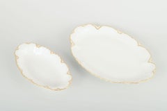 Haviland, France. Paire de plats ovales en porcelaine de couleur crème avec bords dorés.