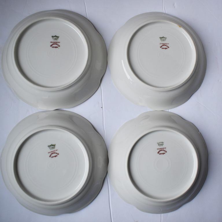 Set of four French white porcelain dishes. Beautiful pieces with scalloped edges and gold rims.