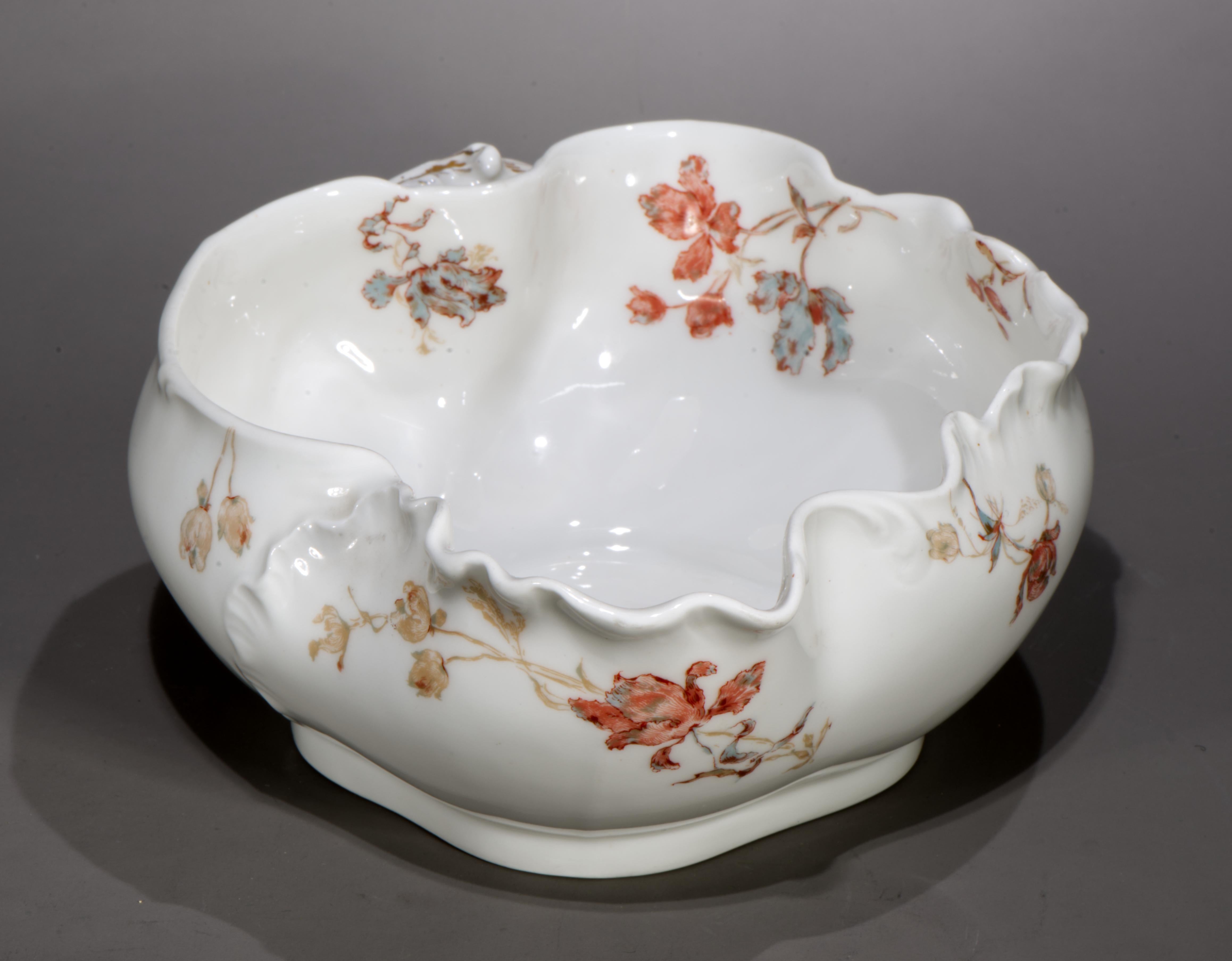 El cuenco ovalado Haviland Limoges tiene forma de Marsella (o Schleiger 9); está decorado con elaborados motivos florales en colores azul, rosa, verde claro y marrón moca, tanto en la superficie interior como en la exterior. El cuenco tiene una