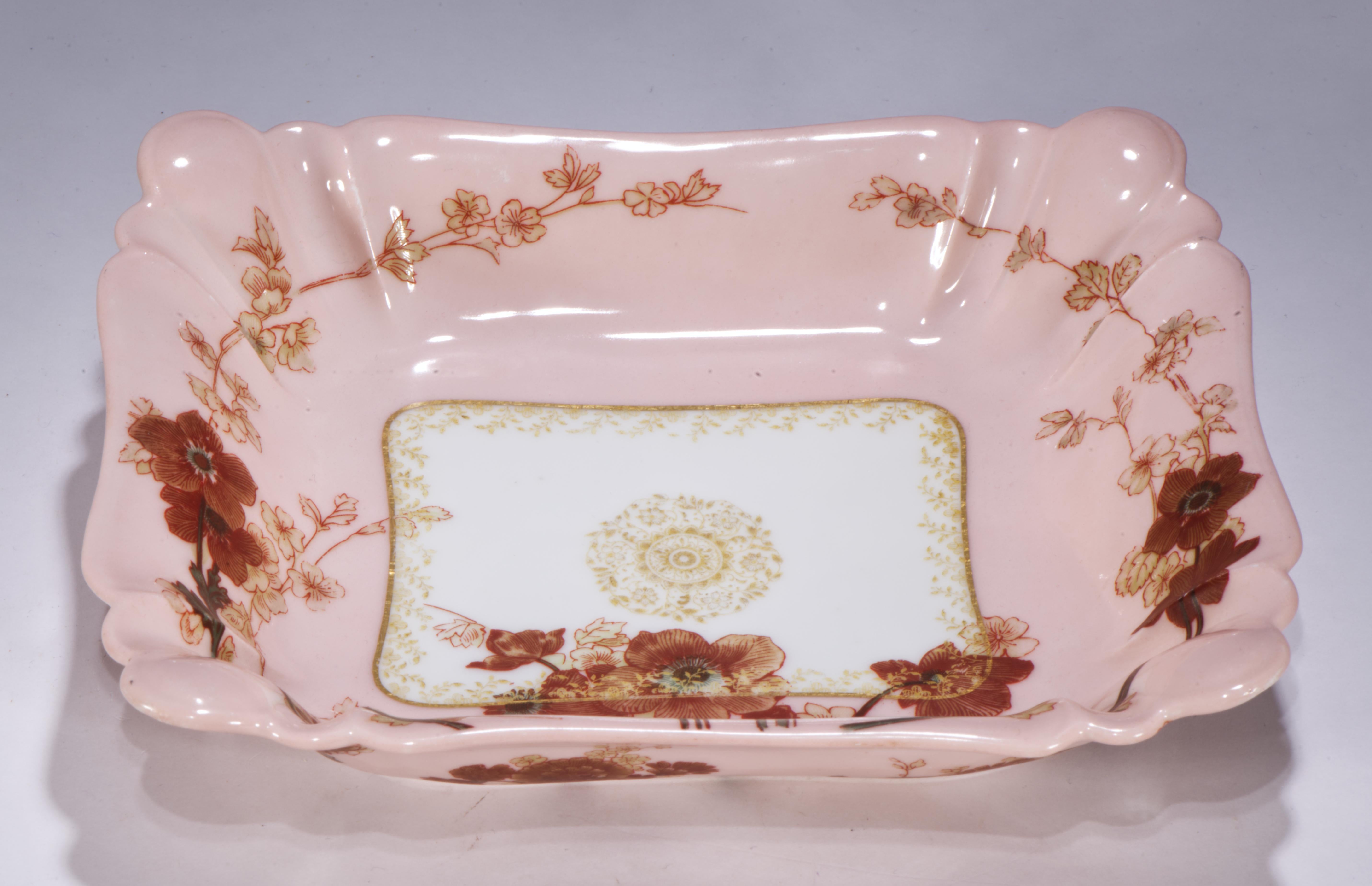Das antike feine Porzellantablett, die Auffangschale, das Kommode-Tablett oder die Schale zeigt ein abstraktes Blumendekor in Gold, Mokkabraun, sanftem Beige und tiefem Jägergrün. Das Blumenmotiv ist auf dem pastellrosa Hintergrund entlang des
