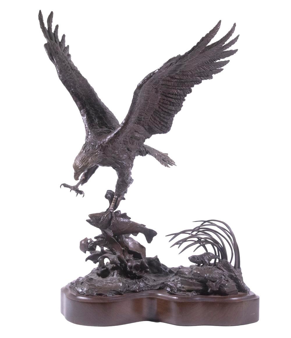 Presented is a patinated bronze eagle by Lorenzo E. Ghiglieri. The eagle is depicted with wings outstretched, catching a salmon with one of his talons. In the reeds below, a beaver hides and watches the scene. The bronze is signed 