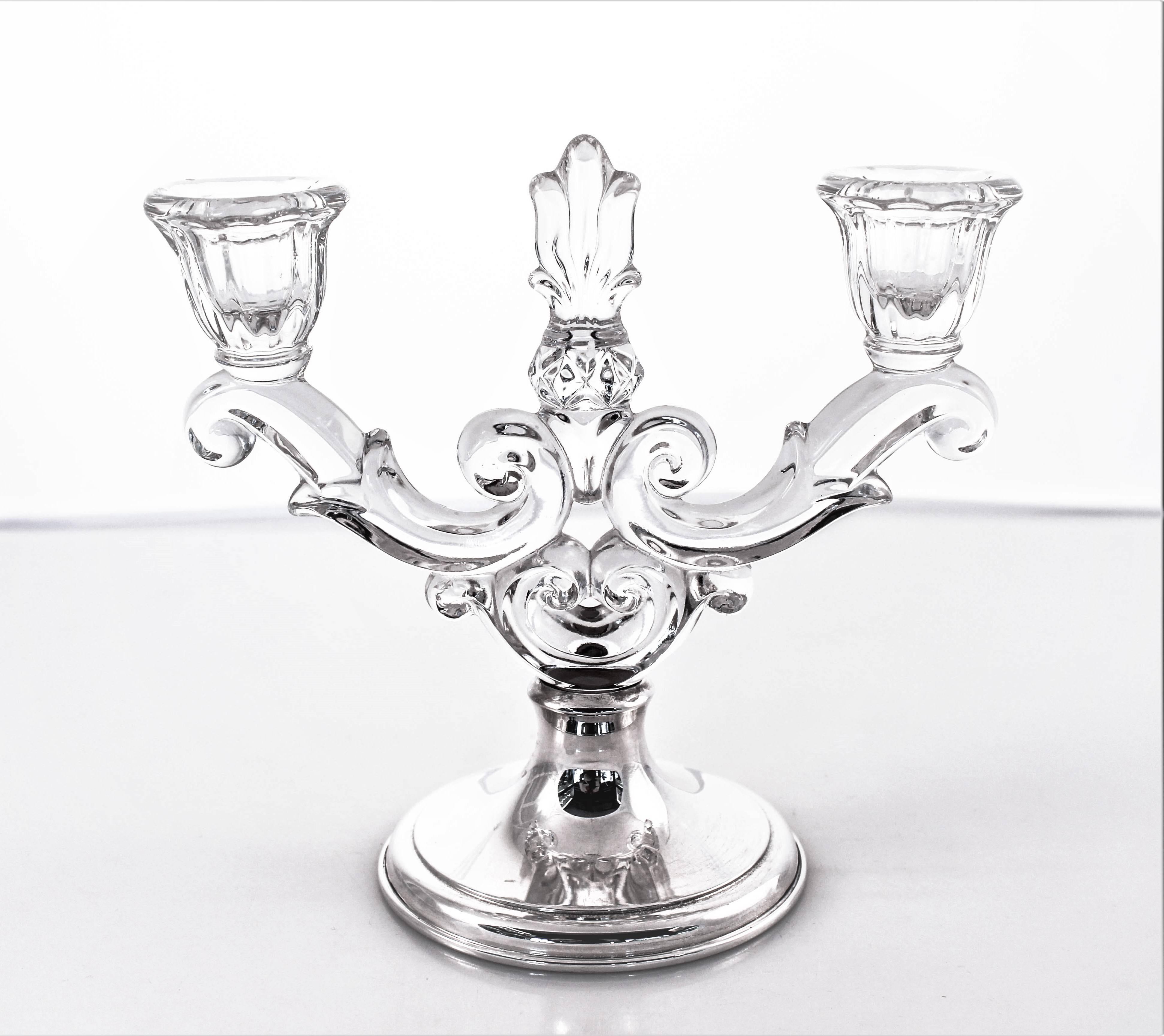 A pair of two-light candelabras from the world famous Hawkes Glass Company in Corning, NY. A simple sterling base compliments the more ornate and detailed crystal top. Elaborate swirls and cut-out work add a dramatic look to these pieces. Display