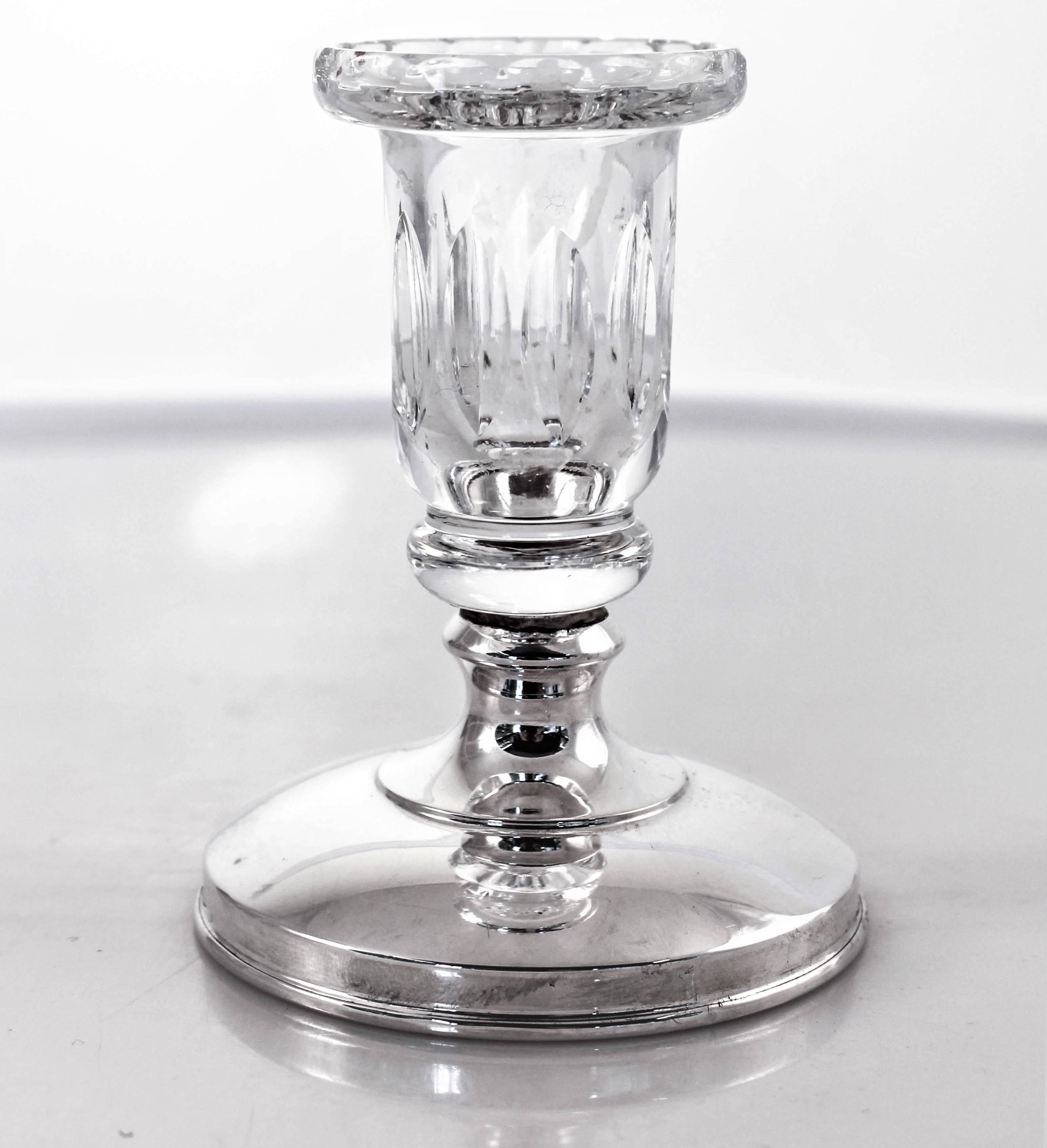 A charming pair of Hawkes crystal and sterling candlesticks. They have oval shaped ridges around the candle holder, a fluted neck and at the top it flares out. The sterling base has a clean simple look. A casual way to dress up your candlelight