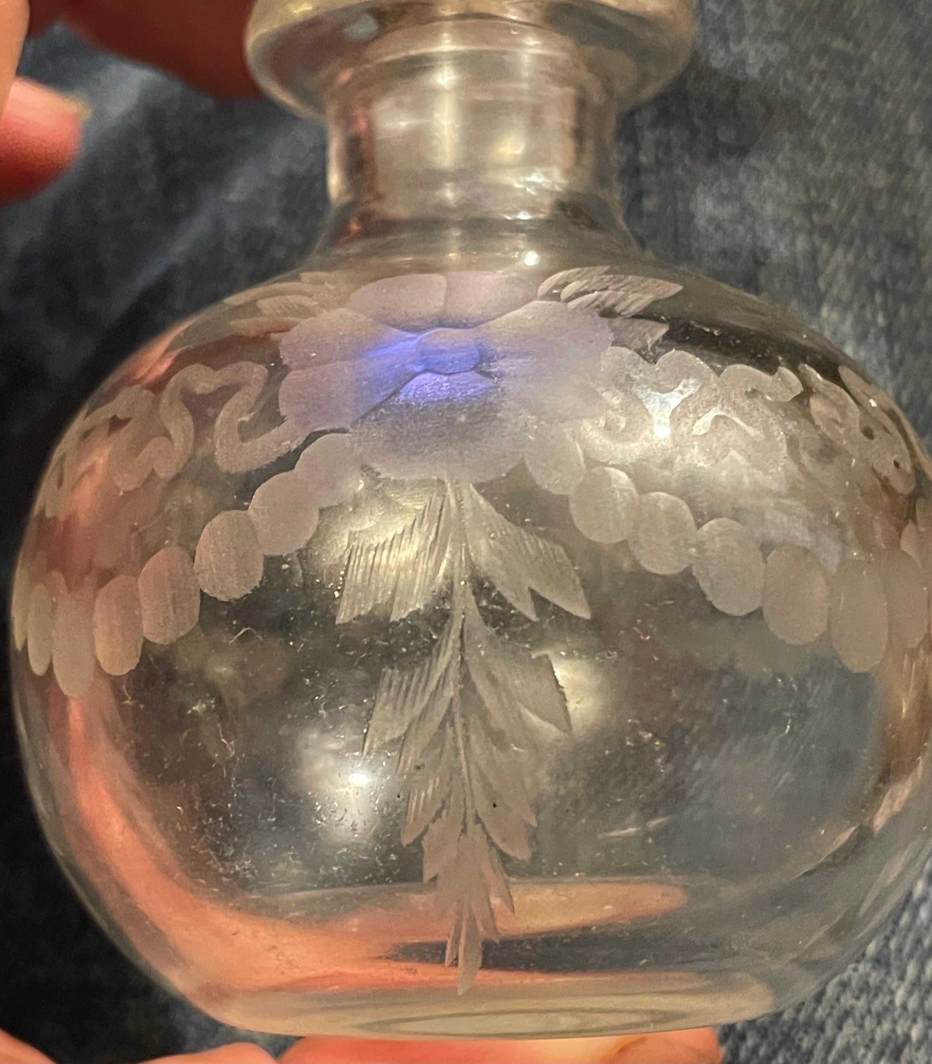 This is a sweet little crystal bottle with a lovely cut floral and swag pattern around the outside, the bottom of the bottle is acid etched Hawkes with the Hawkes symbol. The top of the stopper is cased with sterling silver that is also marked