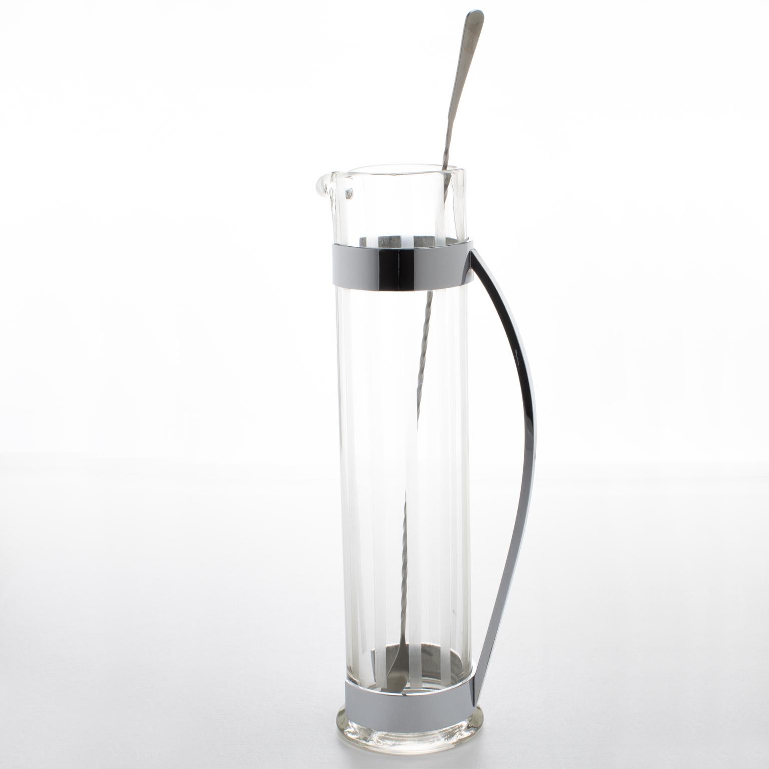 Hawkes Inc. diseñó esta magnífica jarra Art Decó americana de líneas aerodinámicas hacia 1940. El elegante diseño modernista extra alto presenta una jarra o mezclador de Martini soplado a mano y una larga cuchara agitadora. El cuerpo de cristal de
