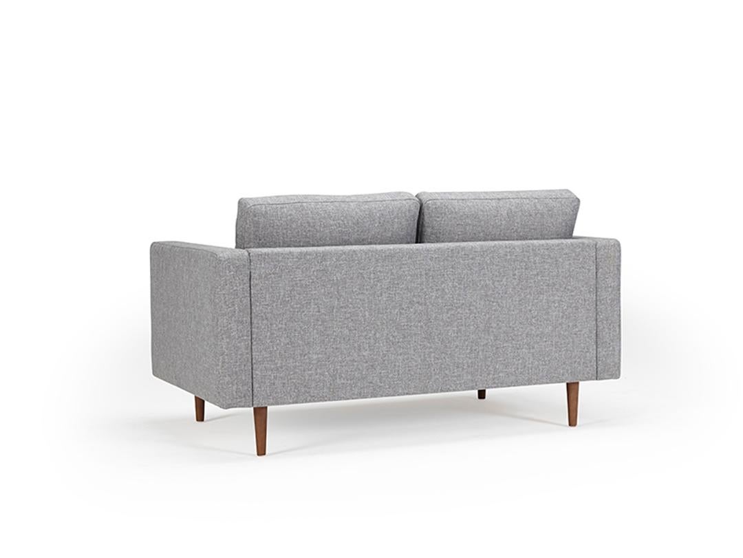 Echoing the timeless appeal of mid-century Scandinavian design, the Clasico 2 Seater Sofa brings together comfort and style. This OEM piece offers customization with various wood finishes for the legs and an array of fabric or leather options for