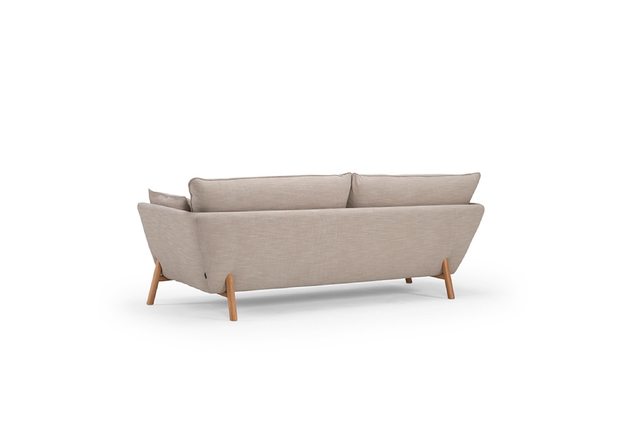 The Nave 2 Seater Sofa, with its clear contemporary allure, offers a harmonious blend of comfort and style. This OEM product, available with either black metal or oak lacquered legs, boasts a variety of fabric or wool upholstery finishes, inviting