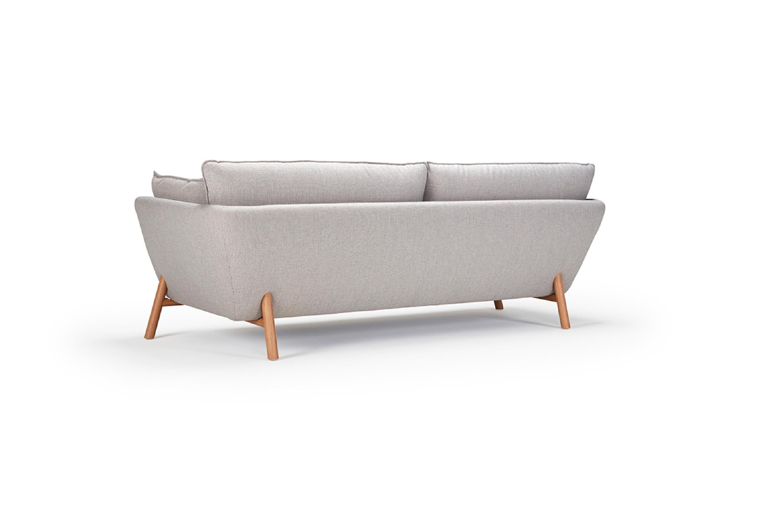 The Nave 2 Seater Sofa, with its clear contemporary allure, offers a harmonious blend of comfort and style. This OEM product, available with either black metal or oak lacquered legs, boasts a variety of fabric or wool upholstery finishes, inviting