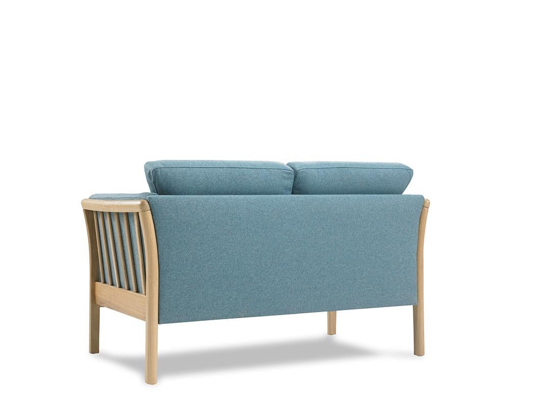 The Oscar 2 Seater Sofa showcases the enduring elegance of classic mid-century Scandinavian modern design. As an OEM product, it offers a range of wood finishes for the legs and a selection of fabric or leather upholstery options. Designed for
