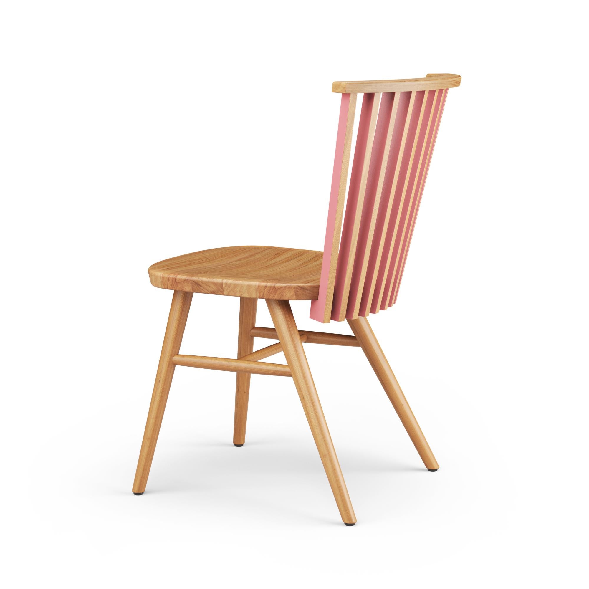 The Tornasol Chair captivates with its ingenious use of solid oak and color, creating a dynamic and visually engaging seating experience. The wooden backrest is composed of several flat solid wood components, each featuring a different color on