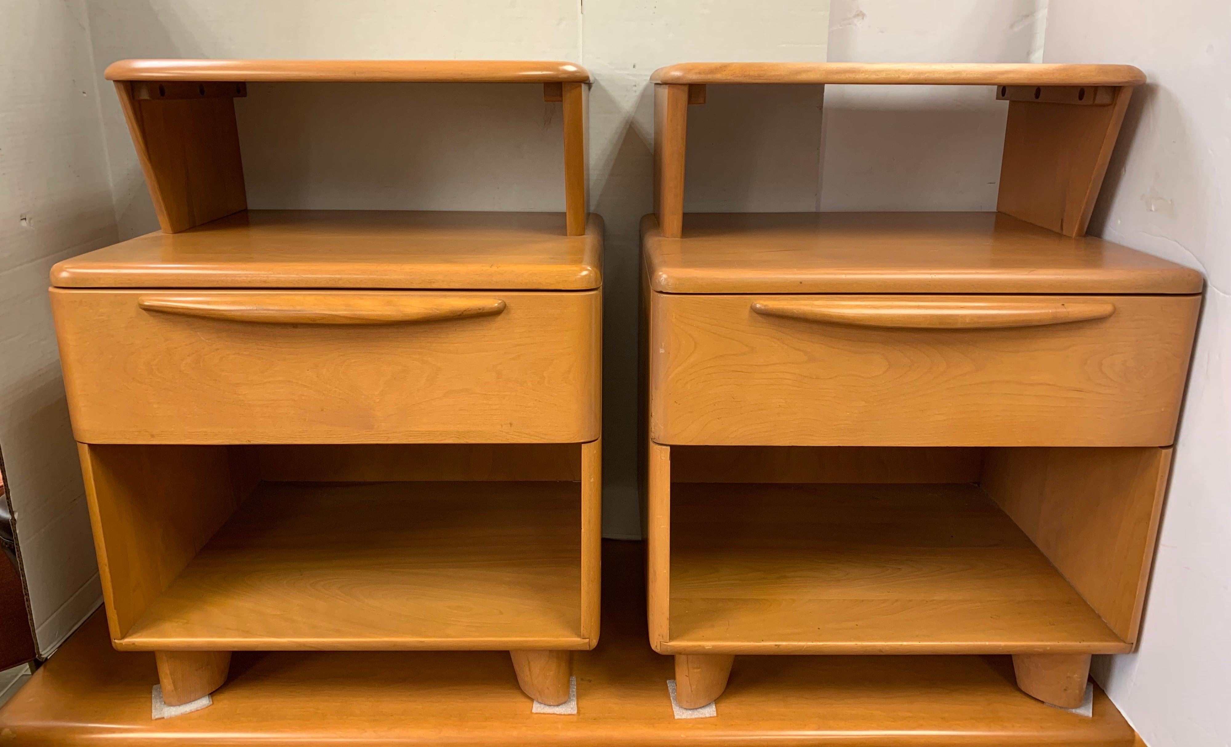 Rare style available with this pair of signed Heywood Wakefield nightstands. Features two levels and drawer.