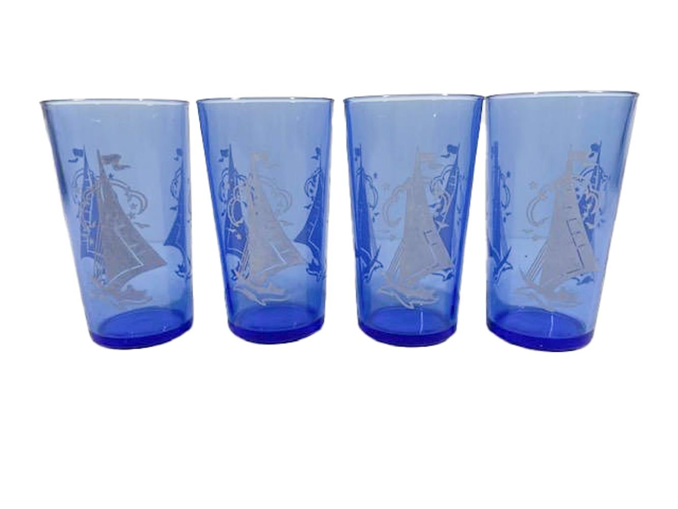 Shakers et 10 verres en verre bleu cobalt avec des scènes de navigation blanches, datant du début du 20e siècle, de la marque Hazel=Atlas. L'ensemble se compose d'un shaker à cocktail avec couvercle chromé bombé, de quatre verres à cocktail et de