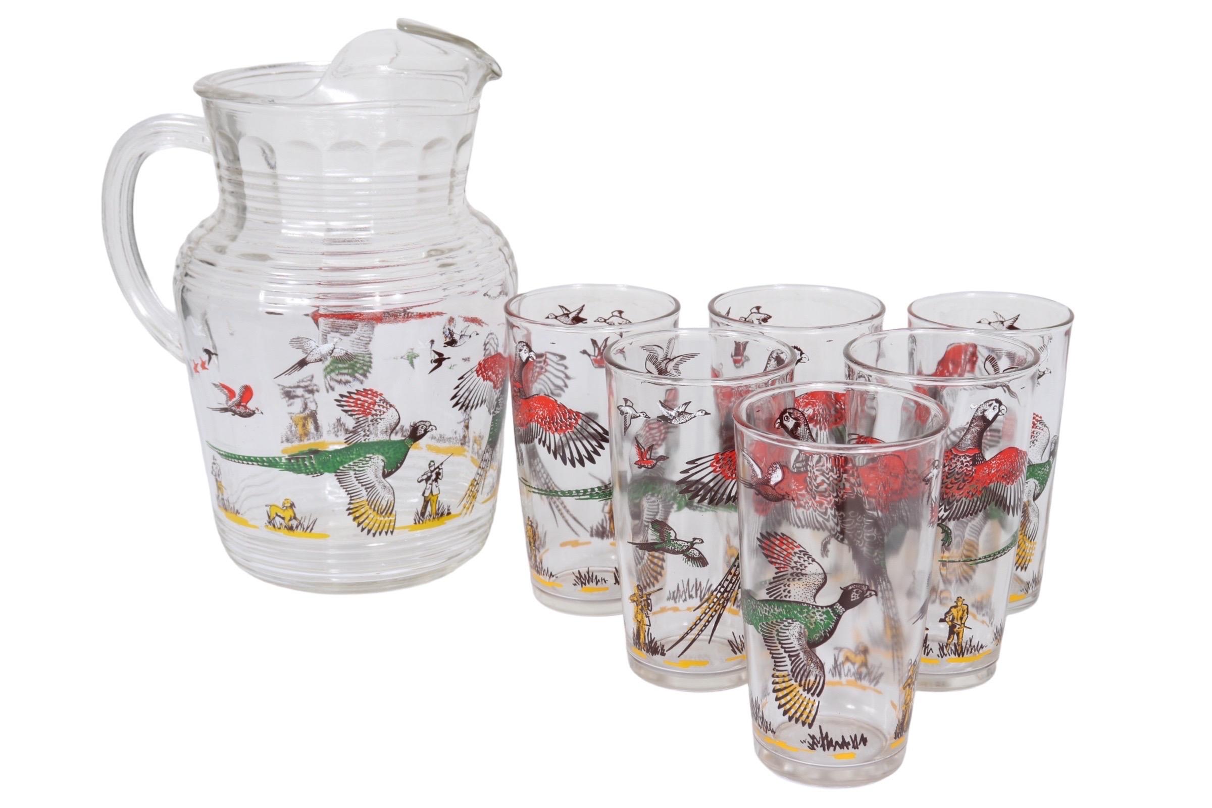 A set of six transferware 8oz highball glasses and matching 80oz pitcher in the Pheasants pattern by Hazel-Atlas Glass Company (1902-1964). Colorful pheasants in red, green and yellow fly above yellow hunters and a dog in a yellow field. Each glass