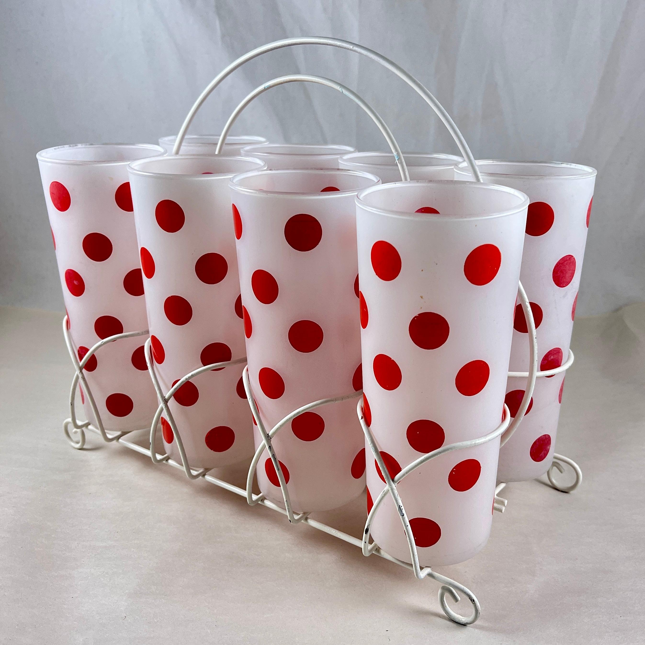 
A charming set of eight polka dotted highballs in a metal caddy, by Hazel-Atlas Glass, circa late 1930s-early 1940s.

Cheerfully perfect for toting to your summer table!

The glasses feature an enameled red dotted pattern on an opaque, frosted